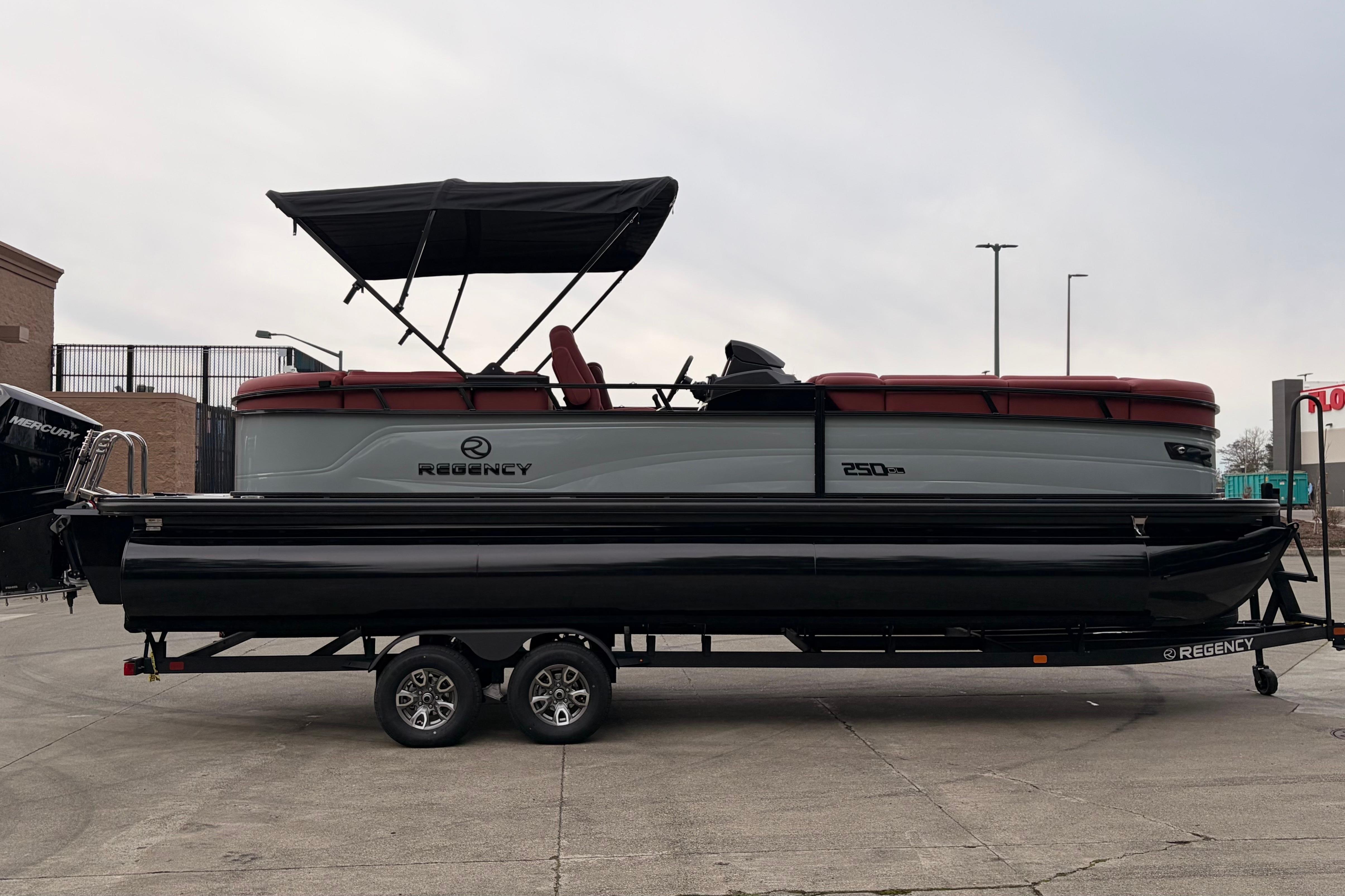 2026 Regency 250 DL pontoon boat on trailer, featuring a sleek design and canopy.
