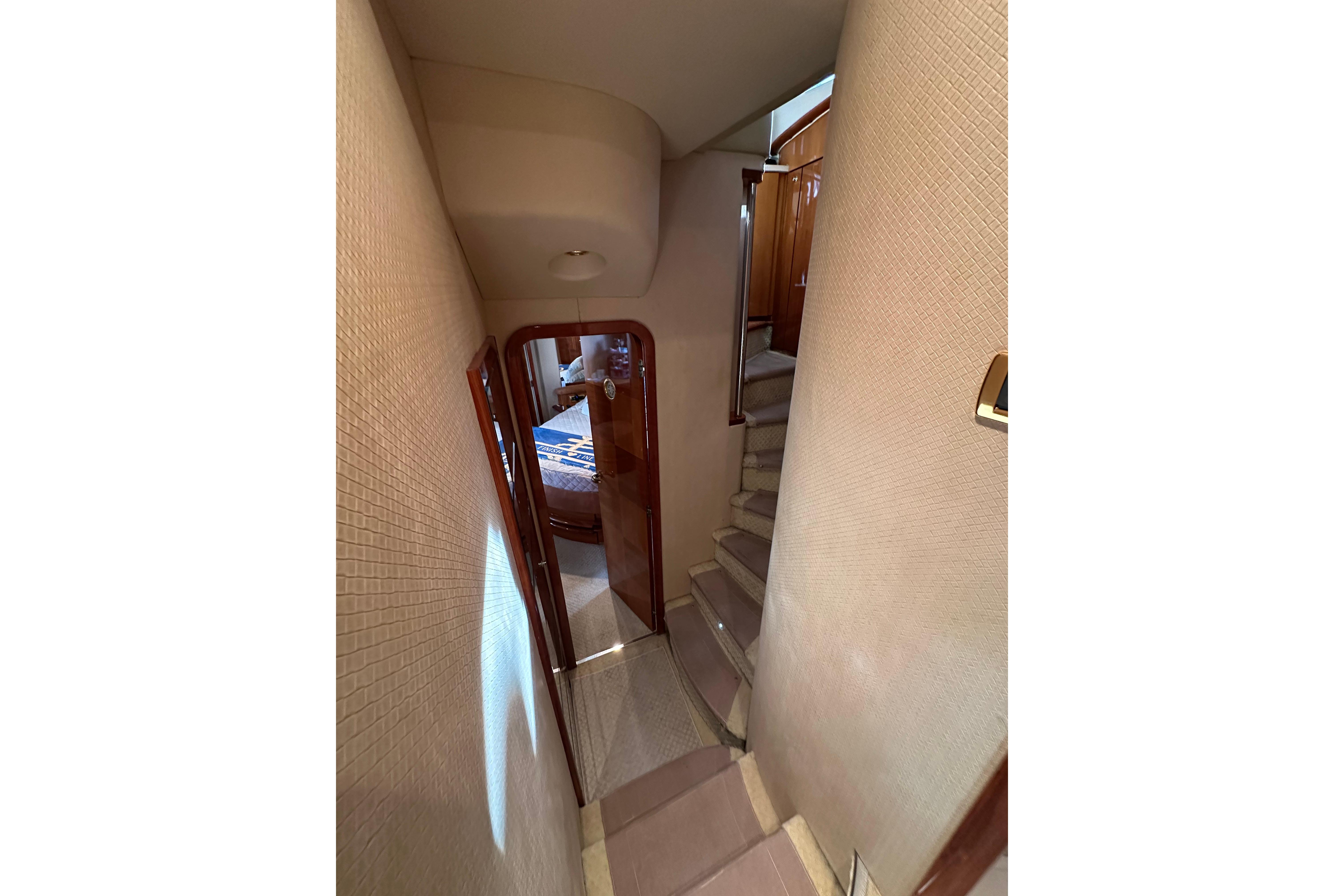 Interior hallway of 2004 Azimut 55E yacht with stairs and cabin door.