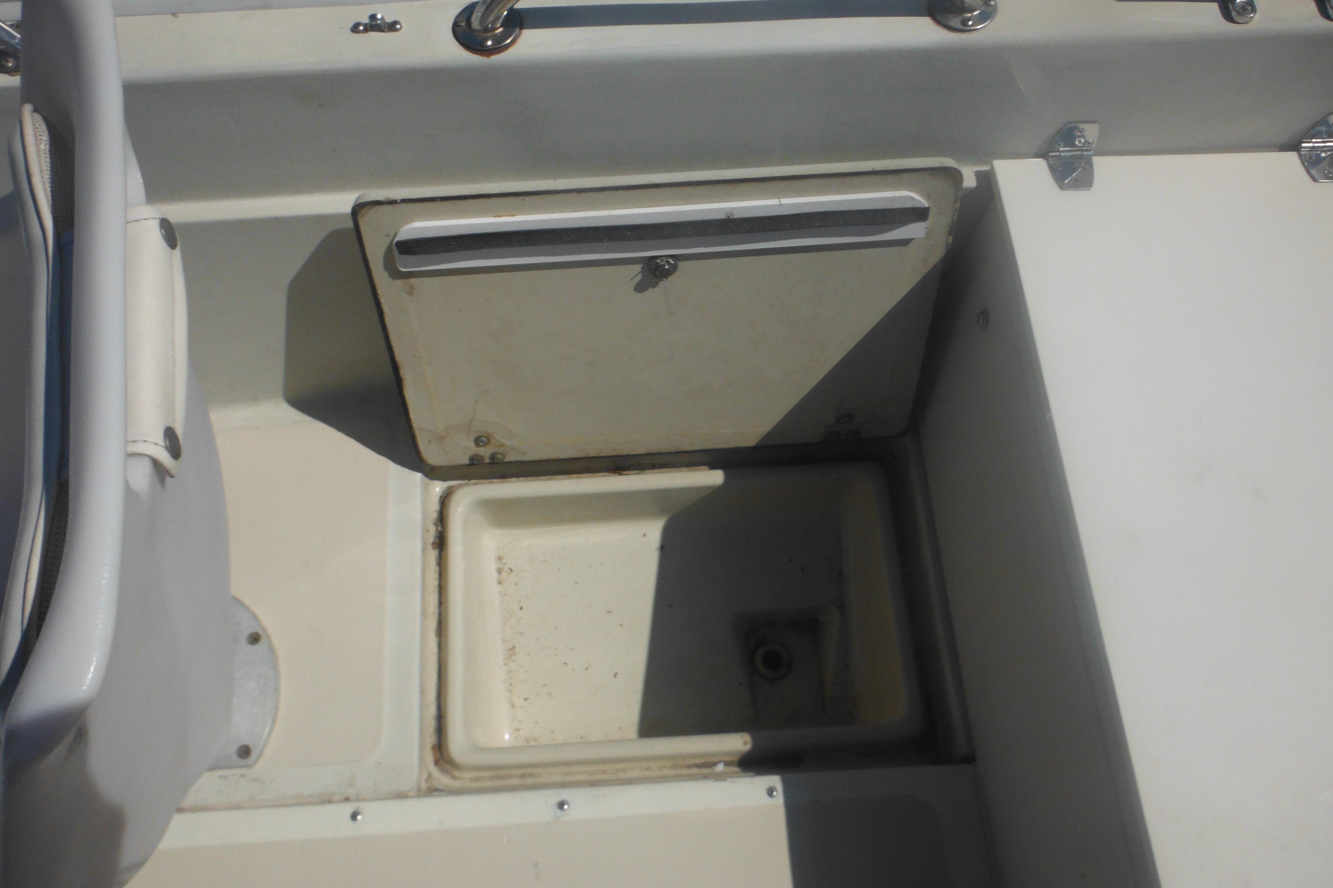 Interior view of a 1991 Boston Whaler 16 SL boat showing storage compartment.