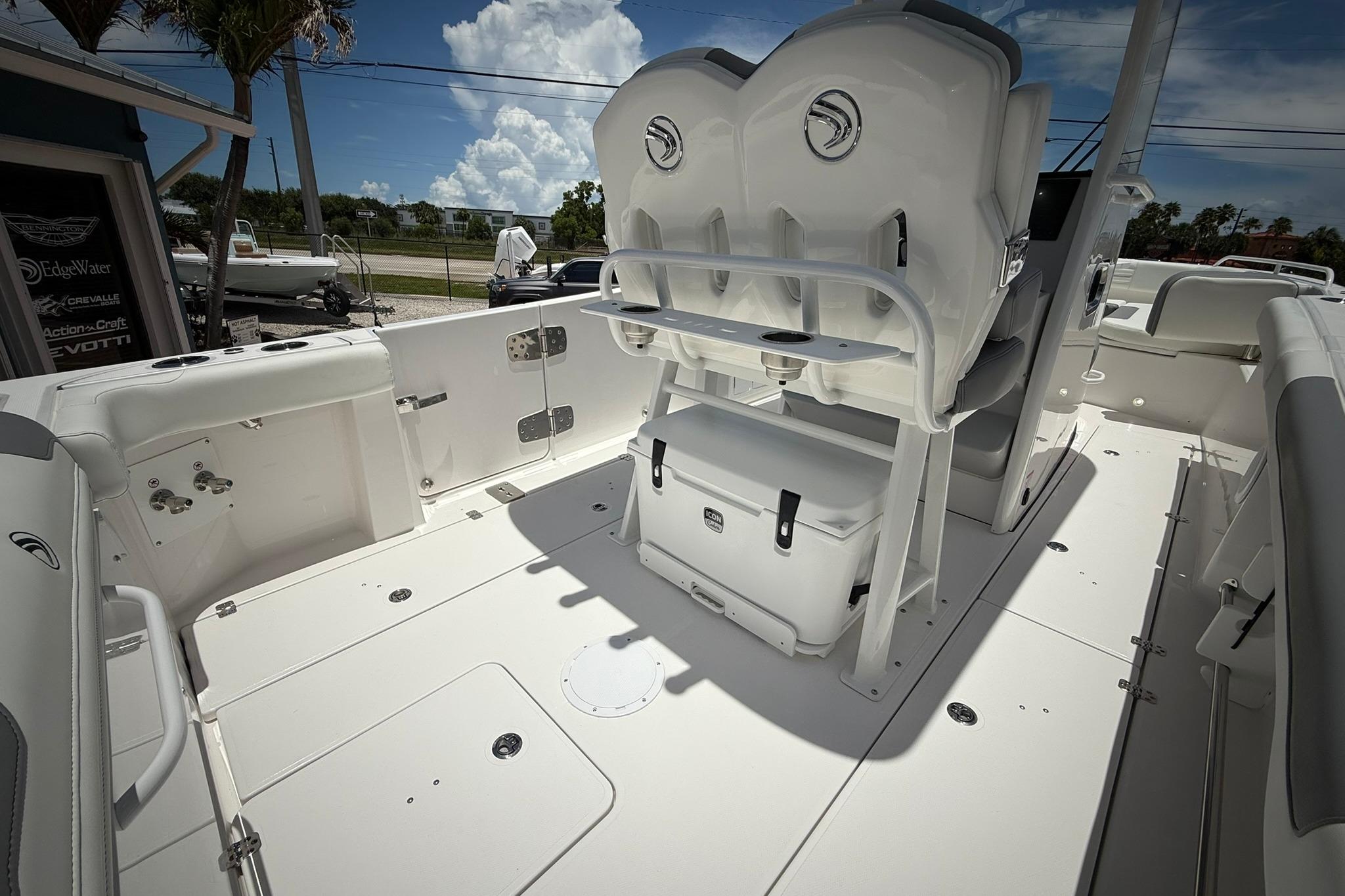 2026 Edgewater 250CC boat interior with seating and storage, under a sunny sky.
