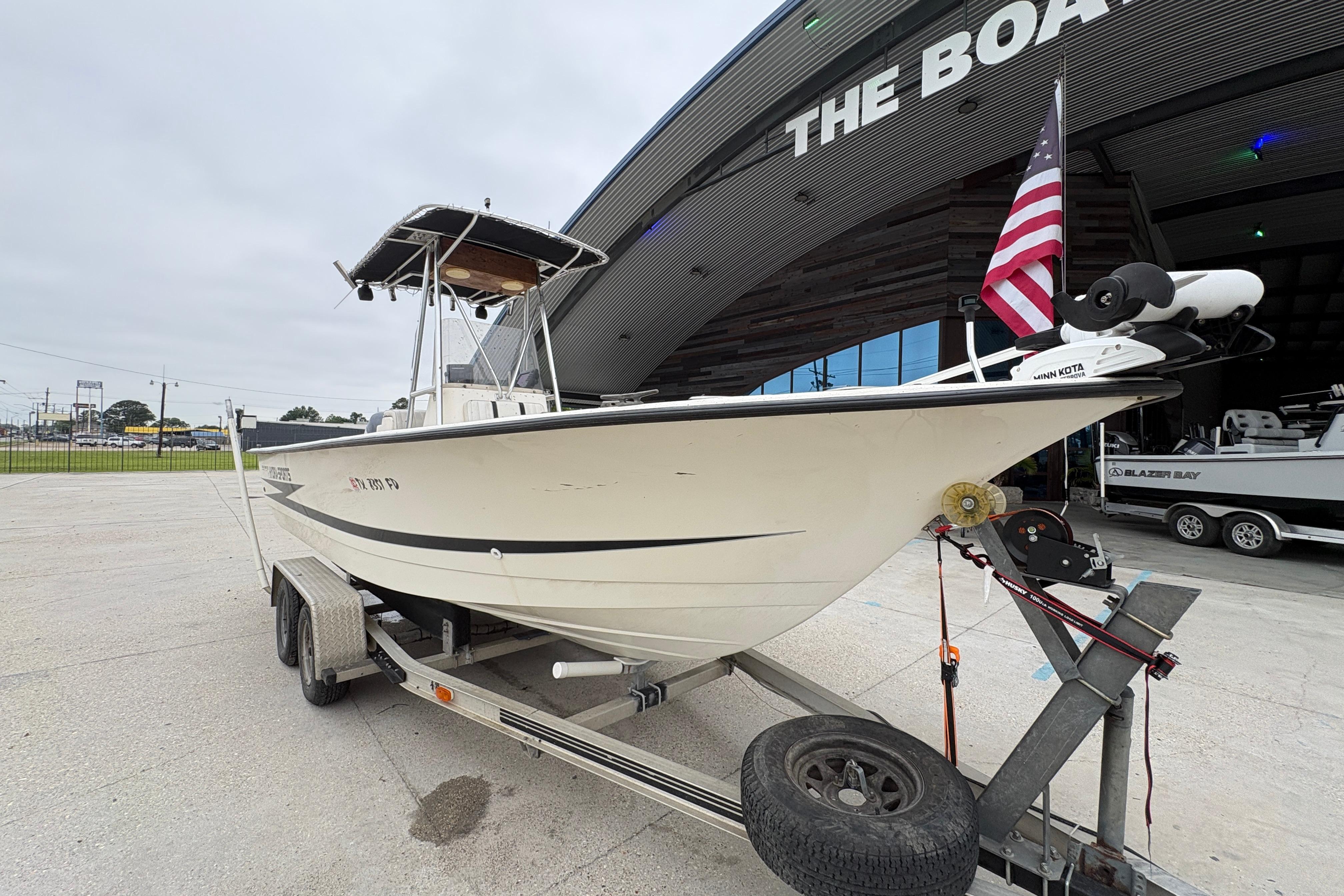 1998 Hydra-Sports 22 Ocean CC boat on trailer, parked outside a large building.