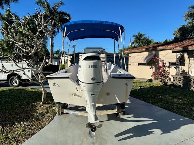 1994 Aquasport Osprey boat with blue canopy on trailer.