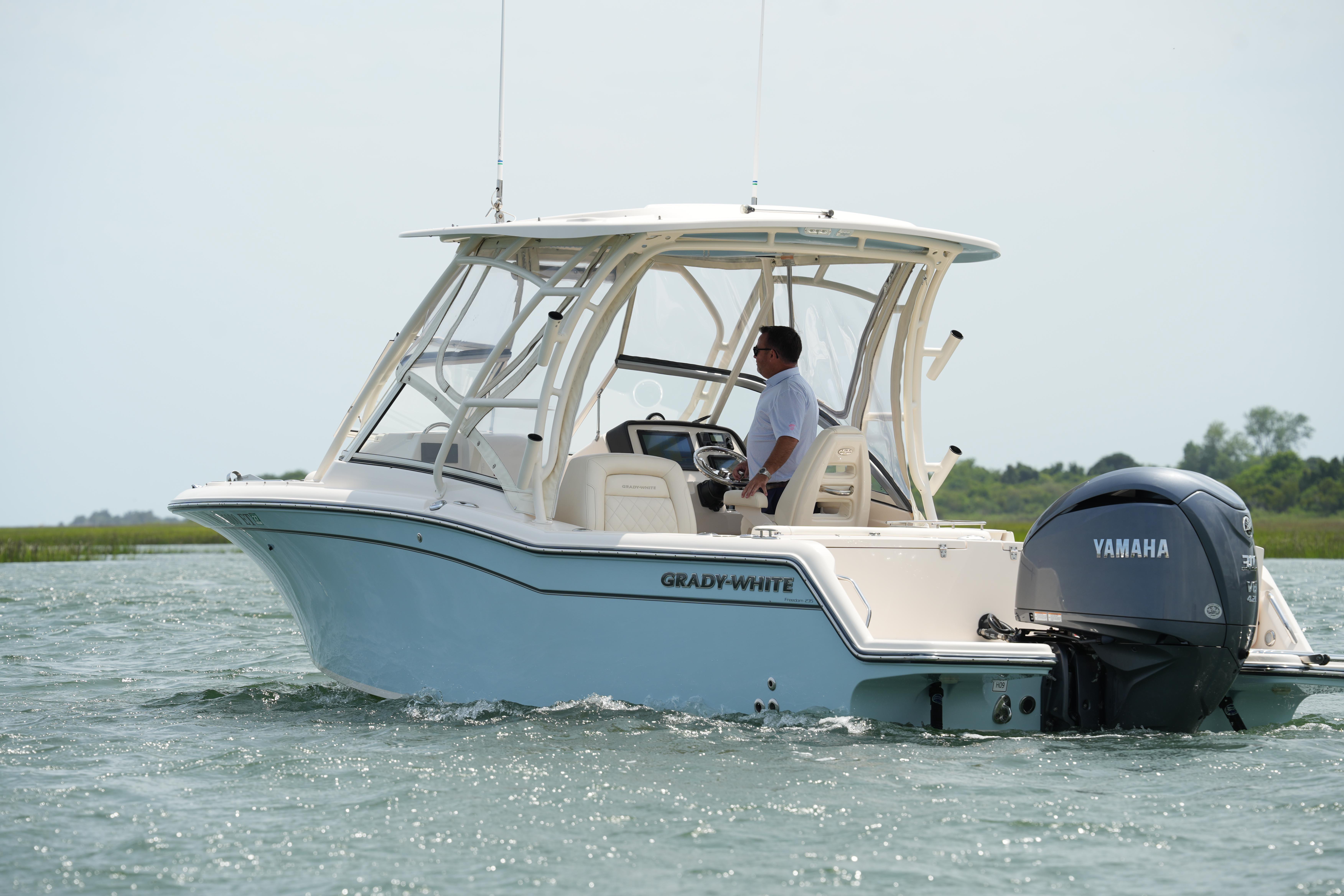 2021 Grady-White Freedom 235 boat cruising with Yamaha engine on a calm waterway.