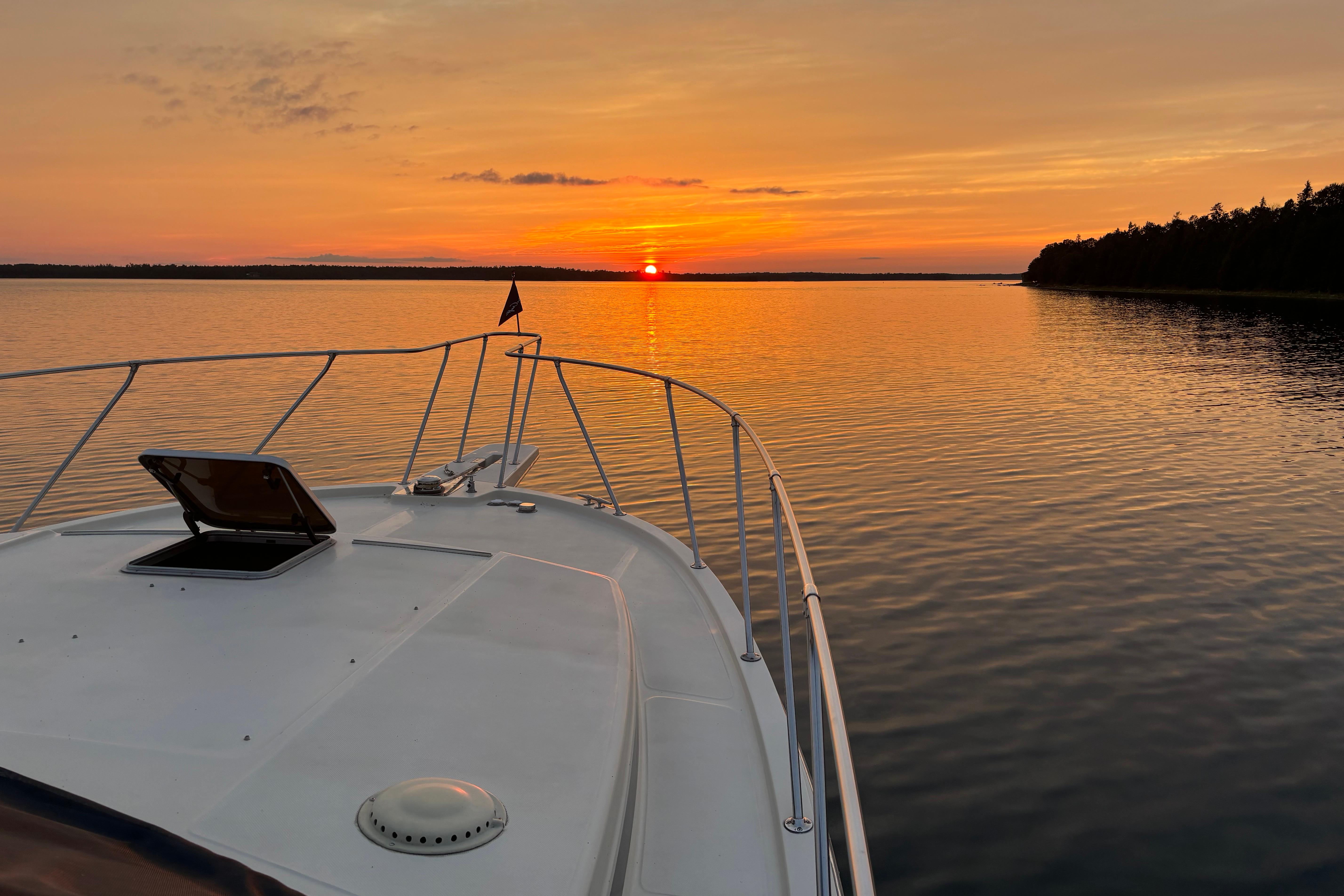Chris-Craft 427 Catalina yacht at sunset on calm waters, 1987 model.