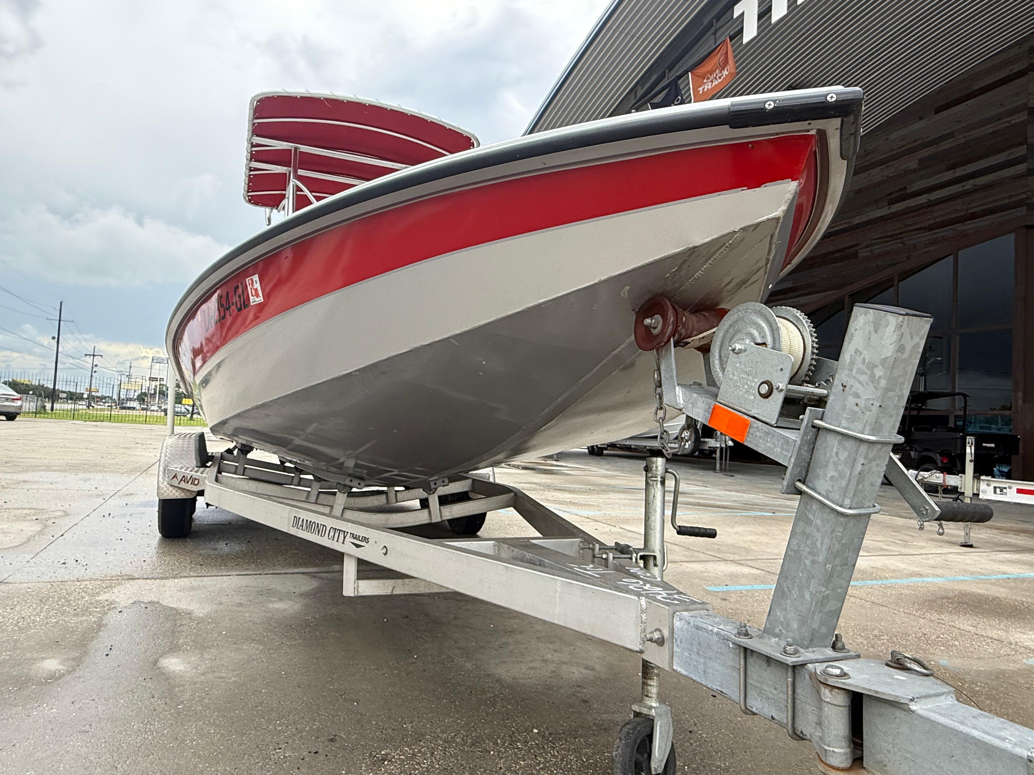 2020 Avid 23 FS Platinum boat on trailer, red and white design, parked outdoors.