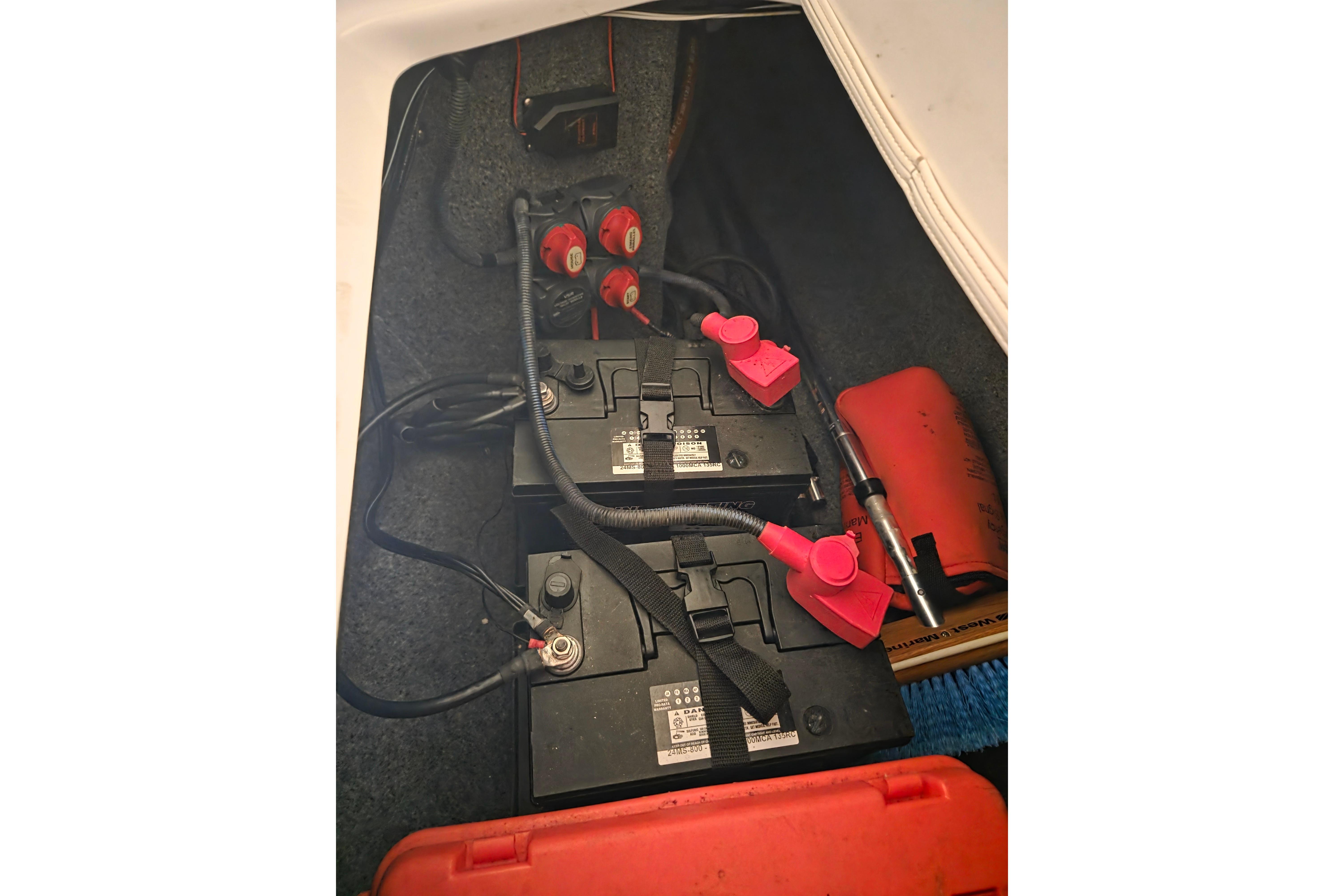 Battery compartment of a 2013 Yamaha 242 Limited S boat with wiring and safety equipment.