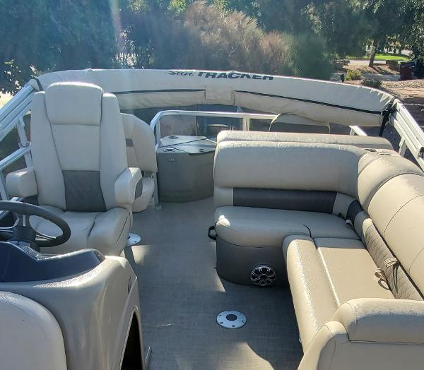 2023 Sun Tracker Party Barge 22 XP3 interior with beige seating and steering console.