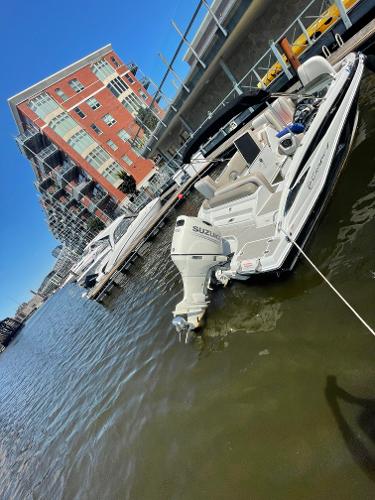 2020 Crownline E 205 XS boat docked near waterfront buildings.