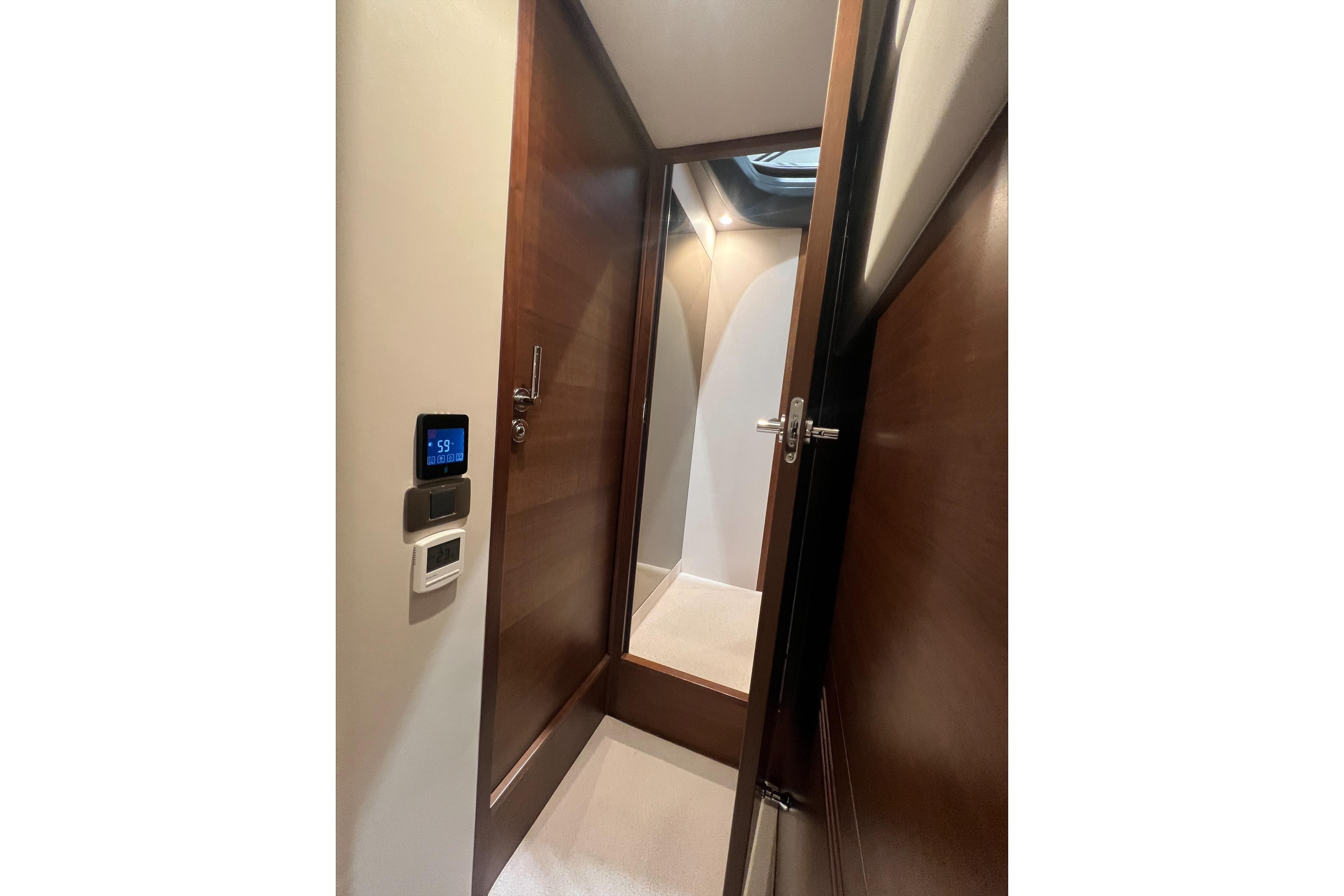 Interior view of 2019 Princess F45 yacht cabin with wooden door and control panel.