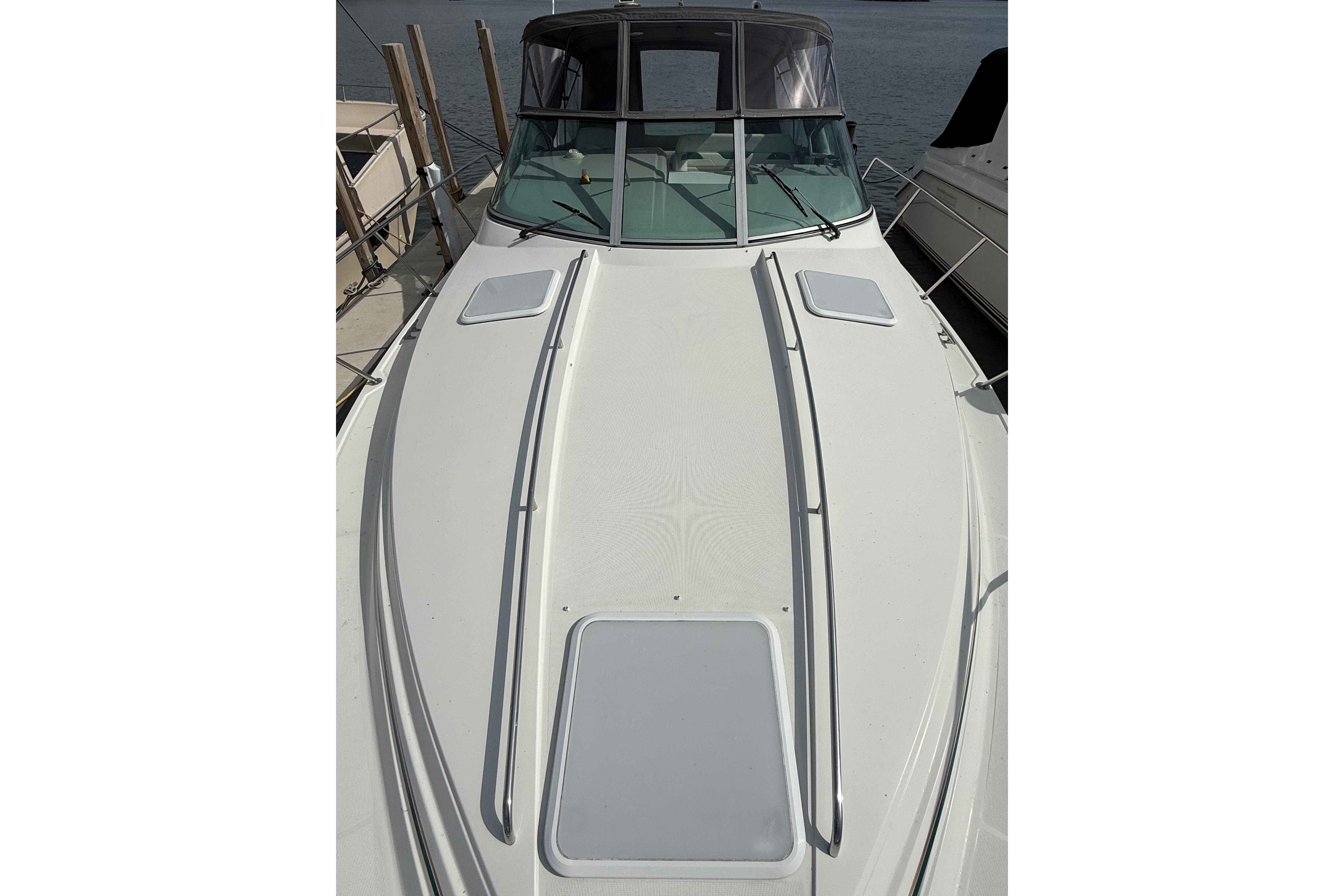 1999 Formula 34 Performance Cruiser boat docked, showcasing sleek white deck design.