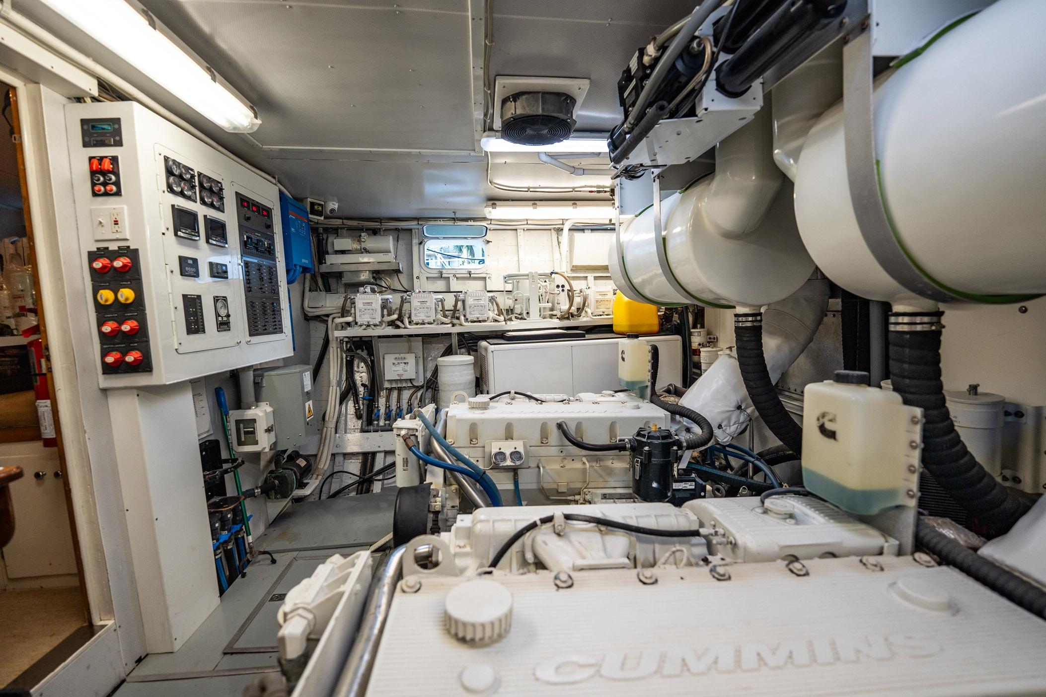 Engine room of a 1972 Trumpy 72 Motor Yacht with Cummins engines and control panels.