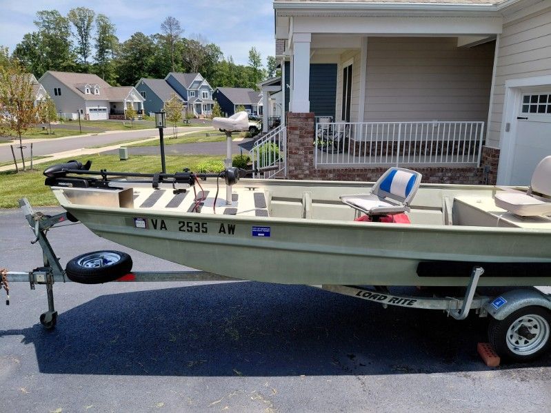A 1999 SeaArk jon boat on a trailer in a residential neighborhood.