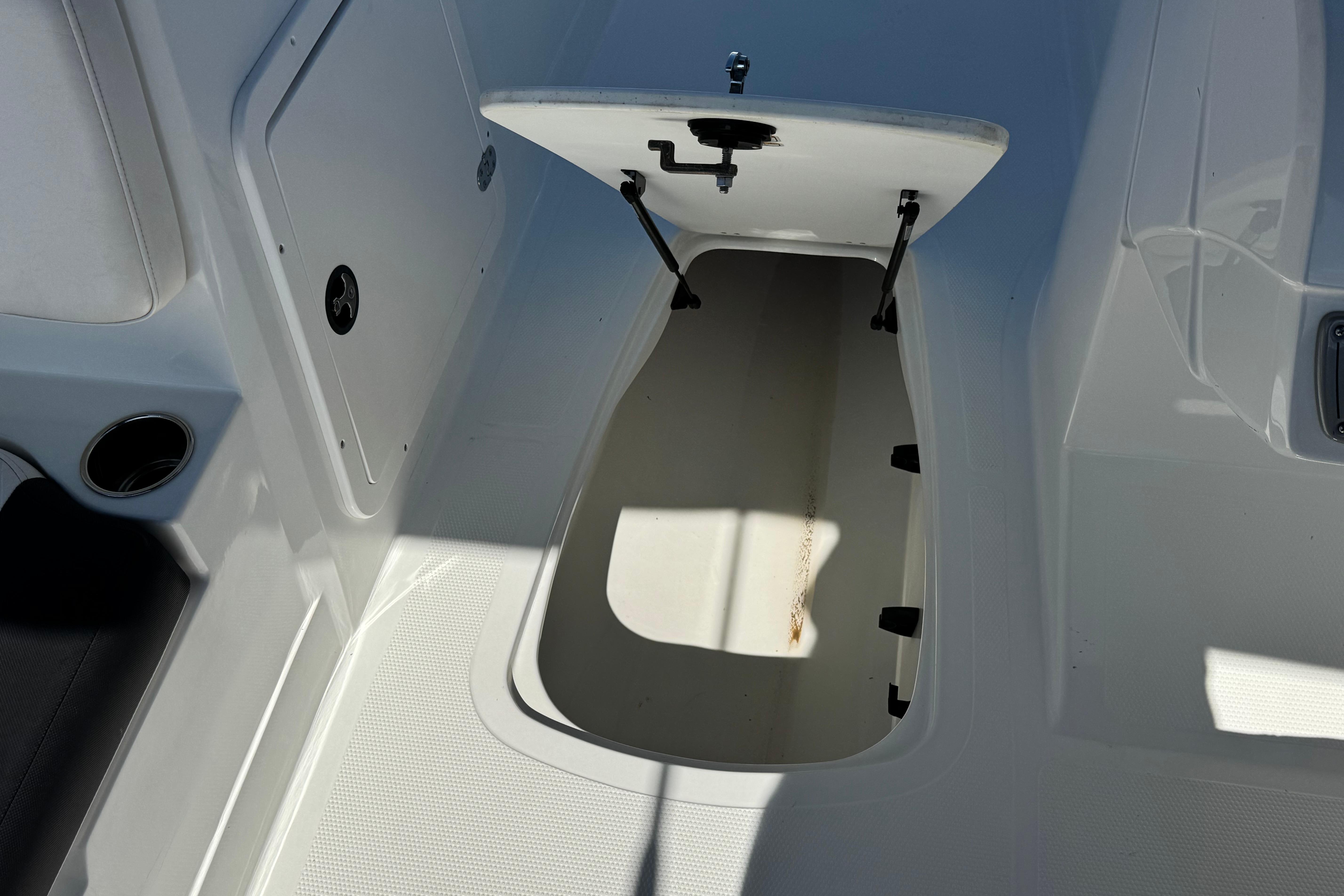 Open storage compartment on 2019 Tahoe 2150 boat deck, showcasing interior space.