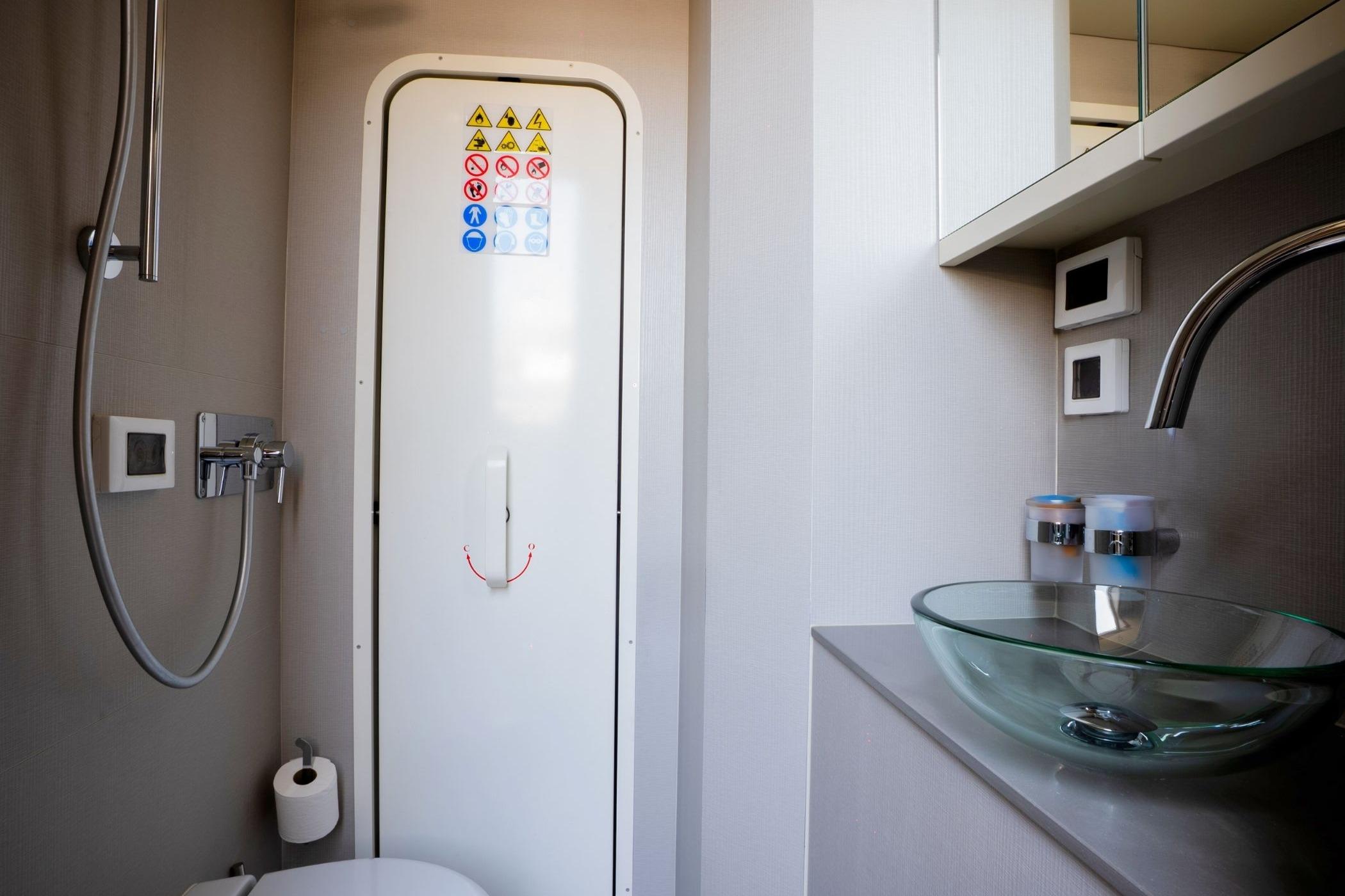 Modern bathroom in 2023 Absolute 68 NAVETTA yacht with glass sink and shower.