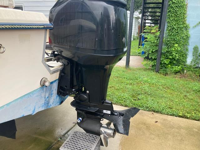 KenCraft Challenger 190 boat with outboard motor, 1995 model, parked on concrete near grass.