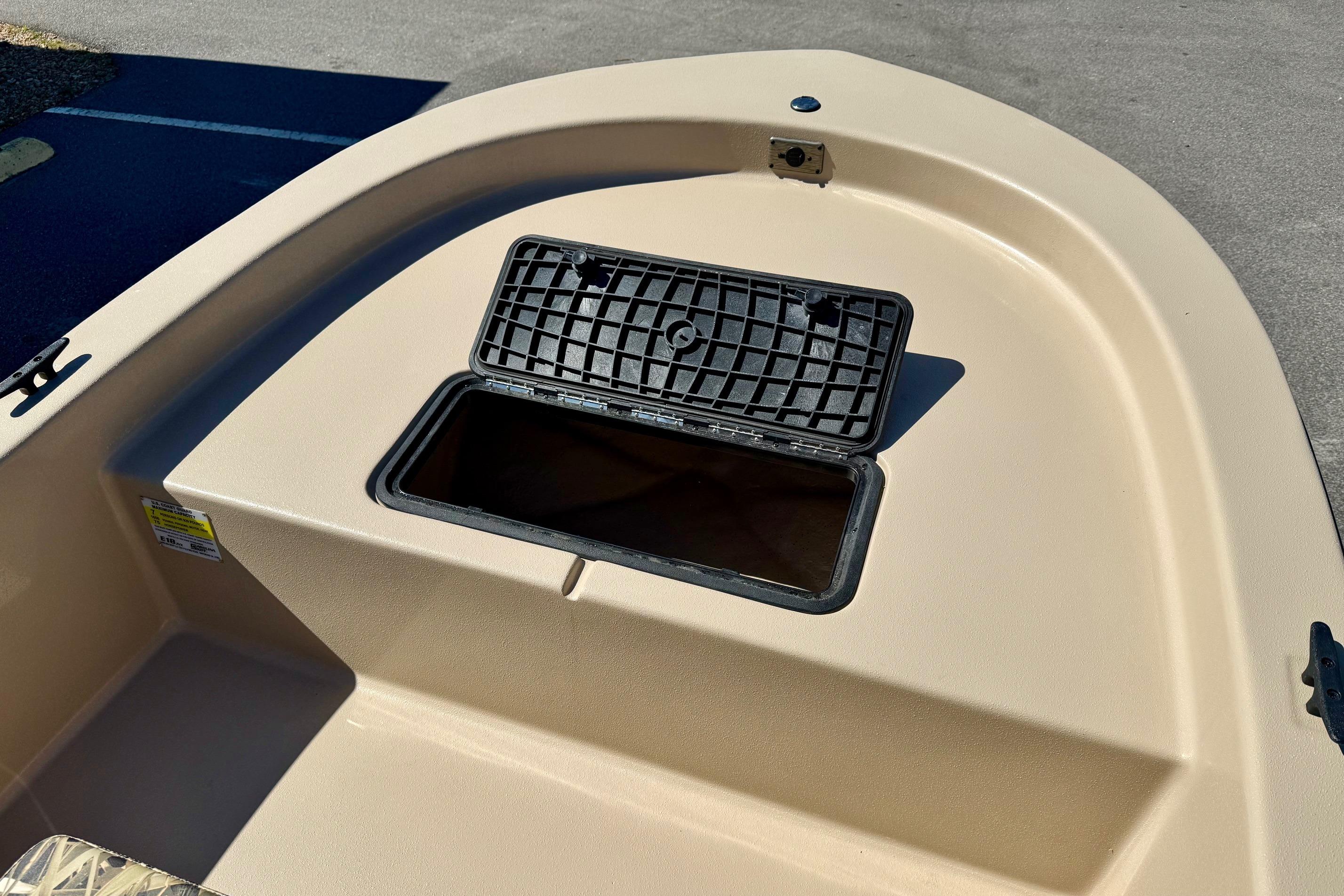 2026 Carolina Skiff E18 JVX CC boat storage compartment, open lid, beige deck.