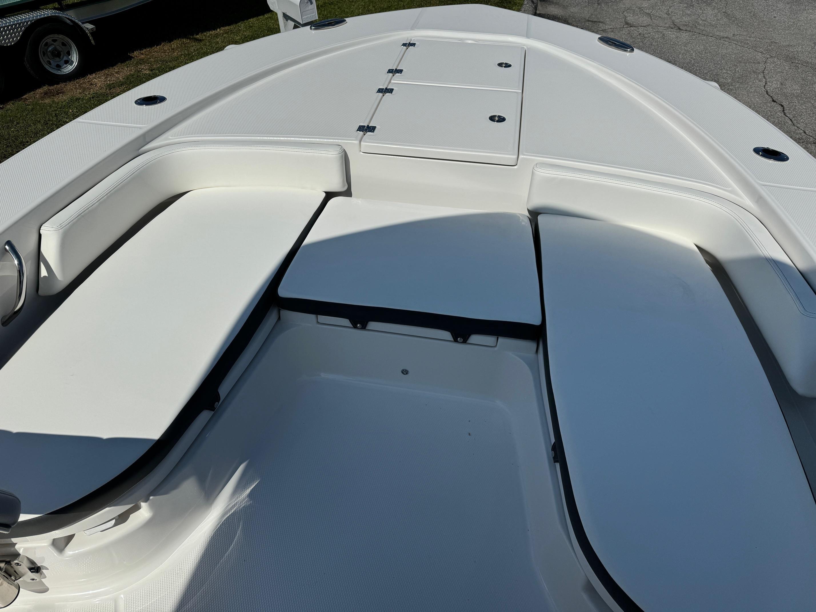 2025 Robalo R246 CAYMAN boat interior with white cushioned seating and storage compartments.