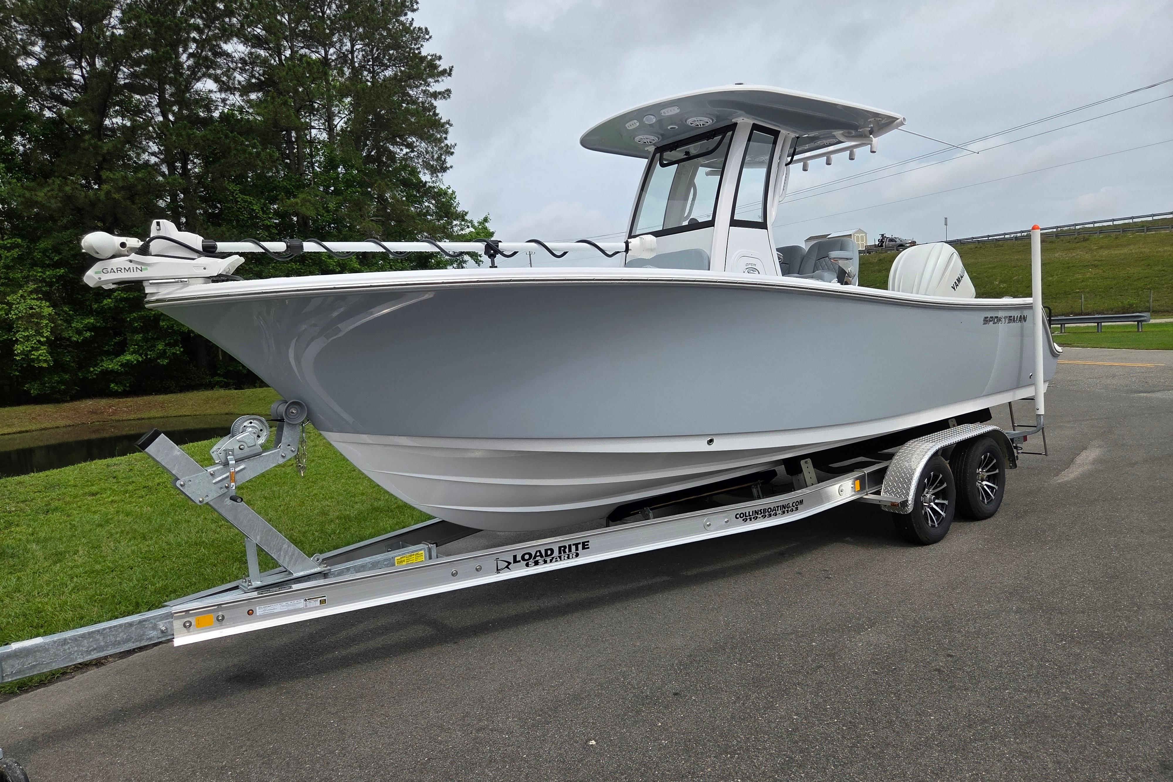 2026 Sportsman Open 232 Center Console boat on trailer, parked outdoors.