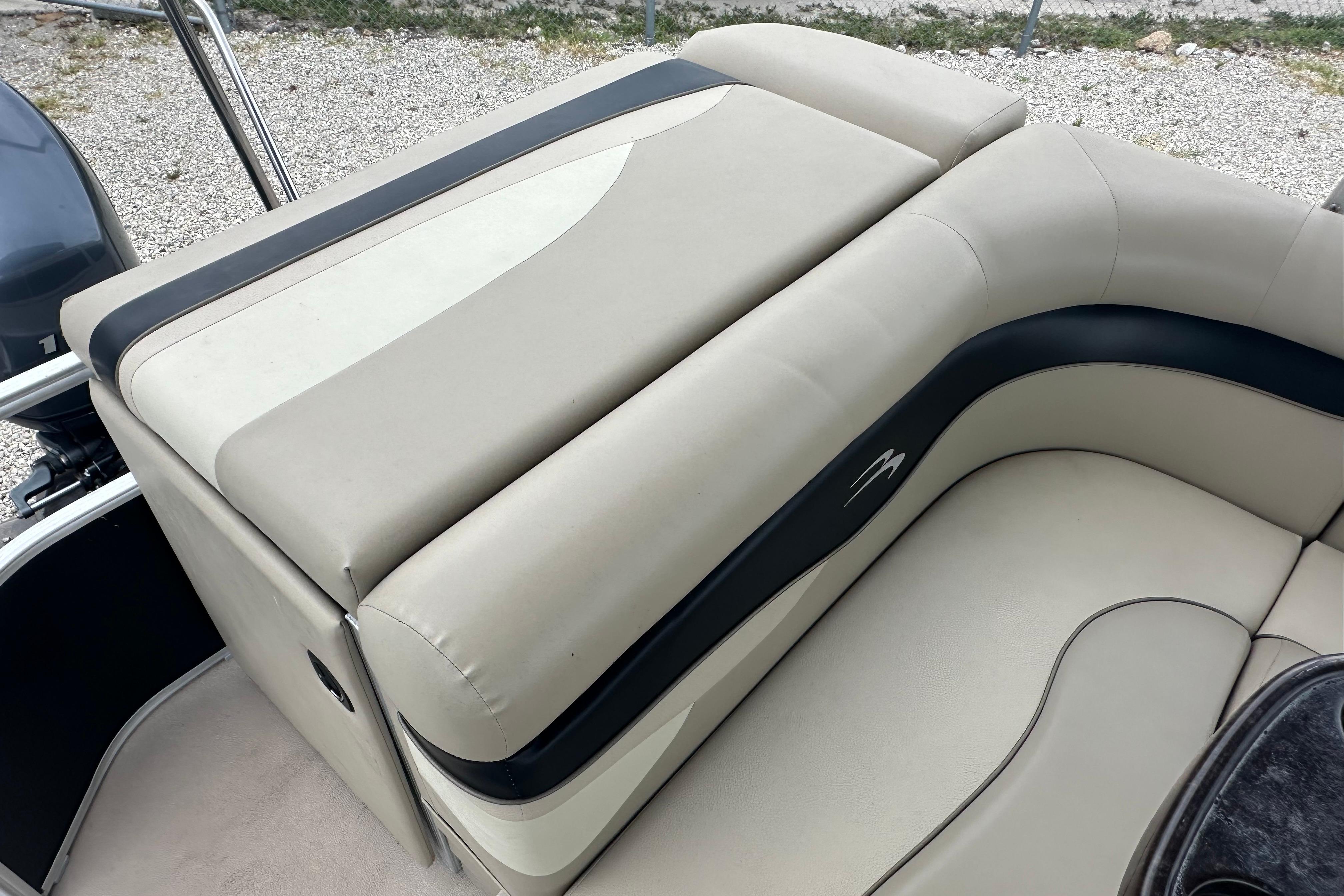 2014 Bennington S22 boat interior with beige and black cushioned seating.