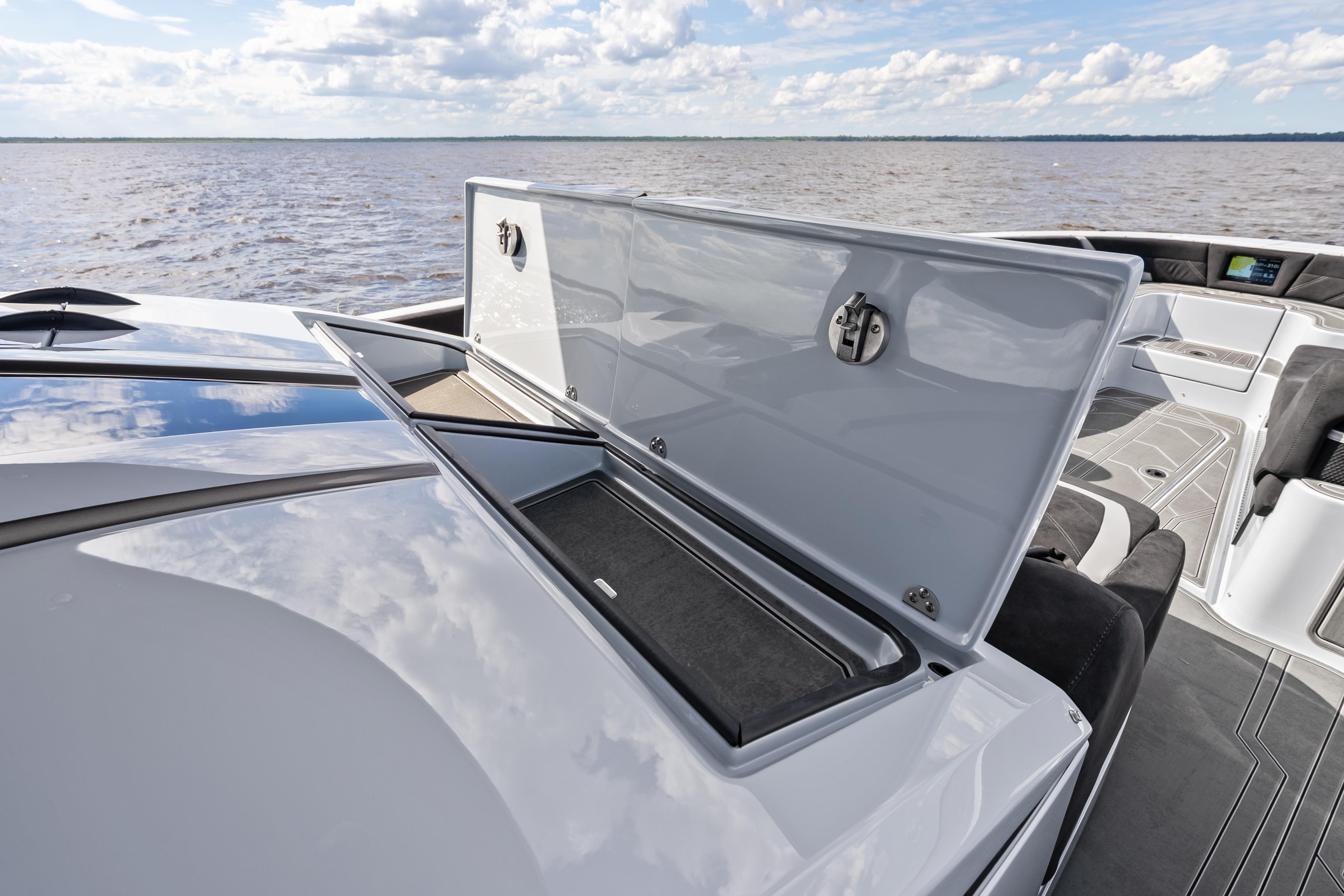 2027 Mystic Powerboats M4200 deck with open storage compartment, on calm waters.