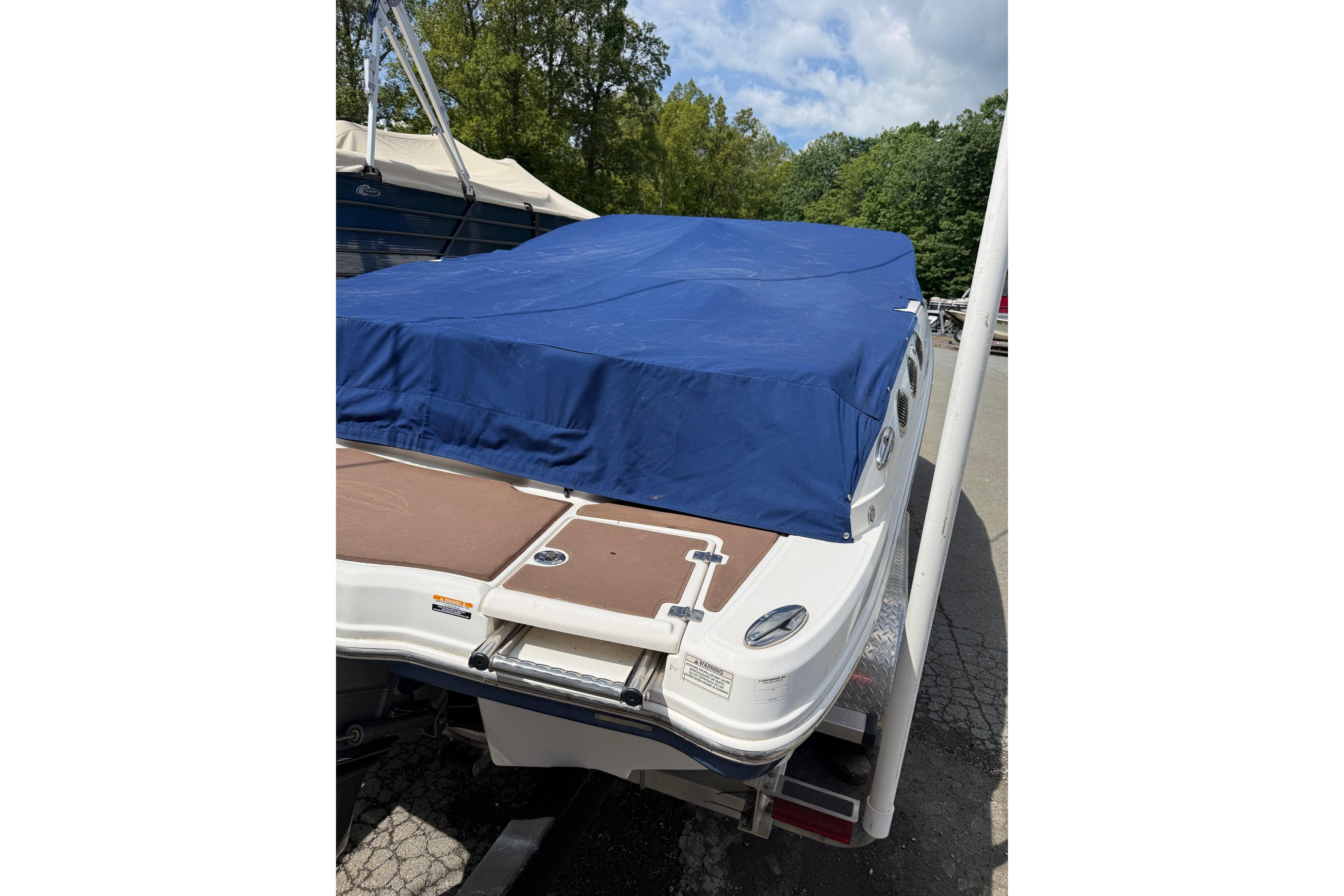 2016 Chaparral 226 SSi Wide Tech boat with blue cover, parked outdoors.