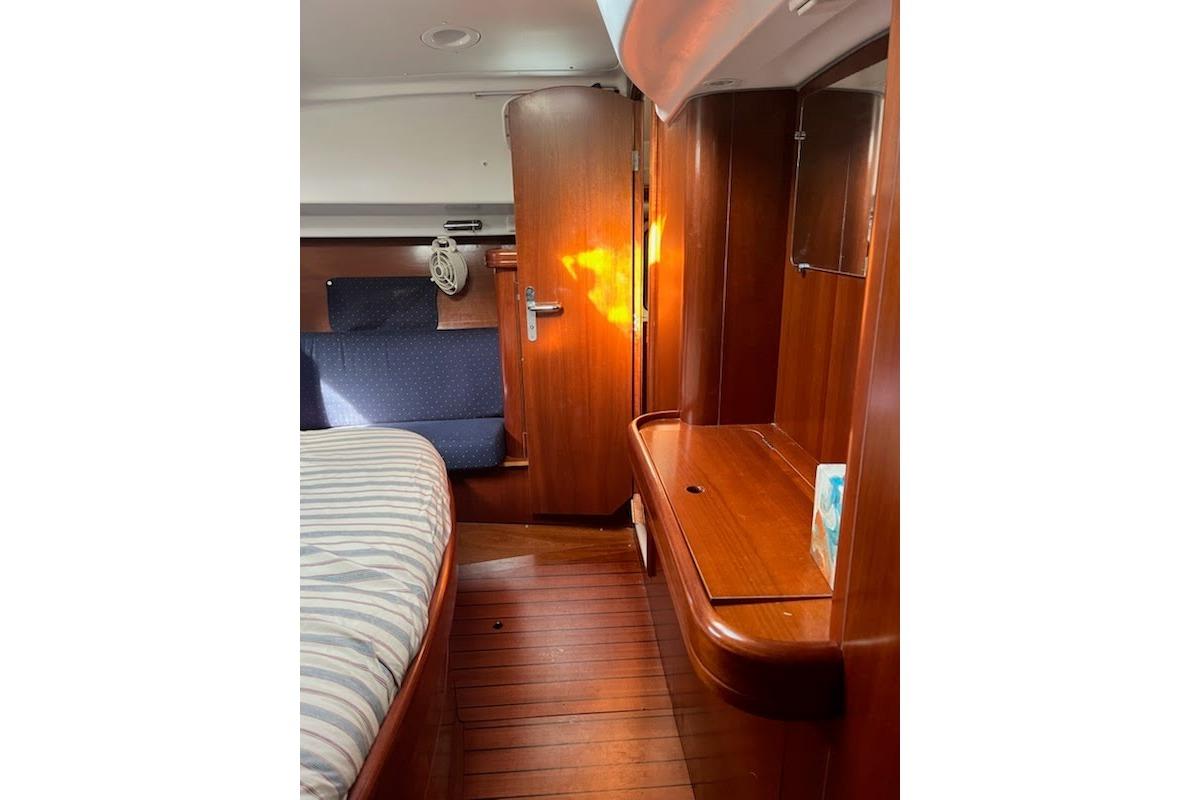 Interior of 2003 Beneteau Oceanis 42CC yacht with wooden furnishings and cozy seating.