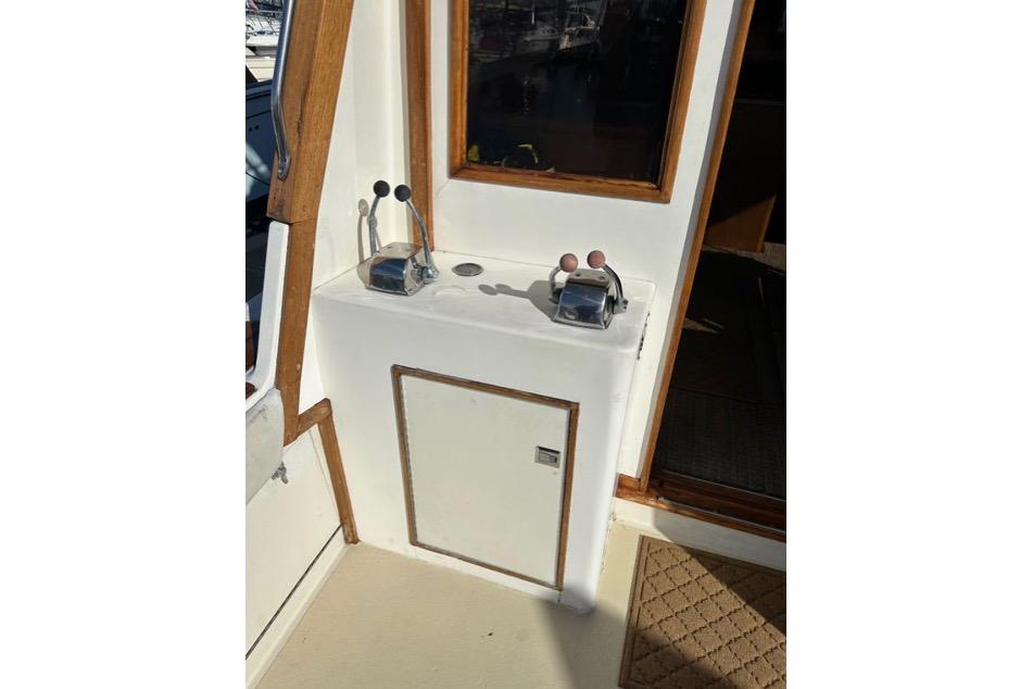 1985 Egg Harbor 33 Sedan boat controls with wooden trim and door.