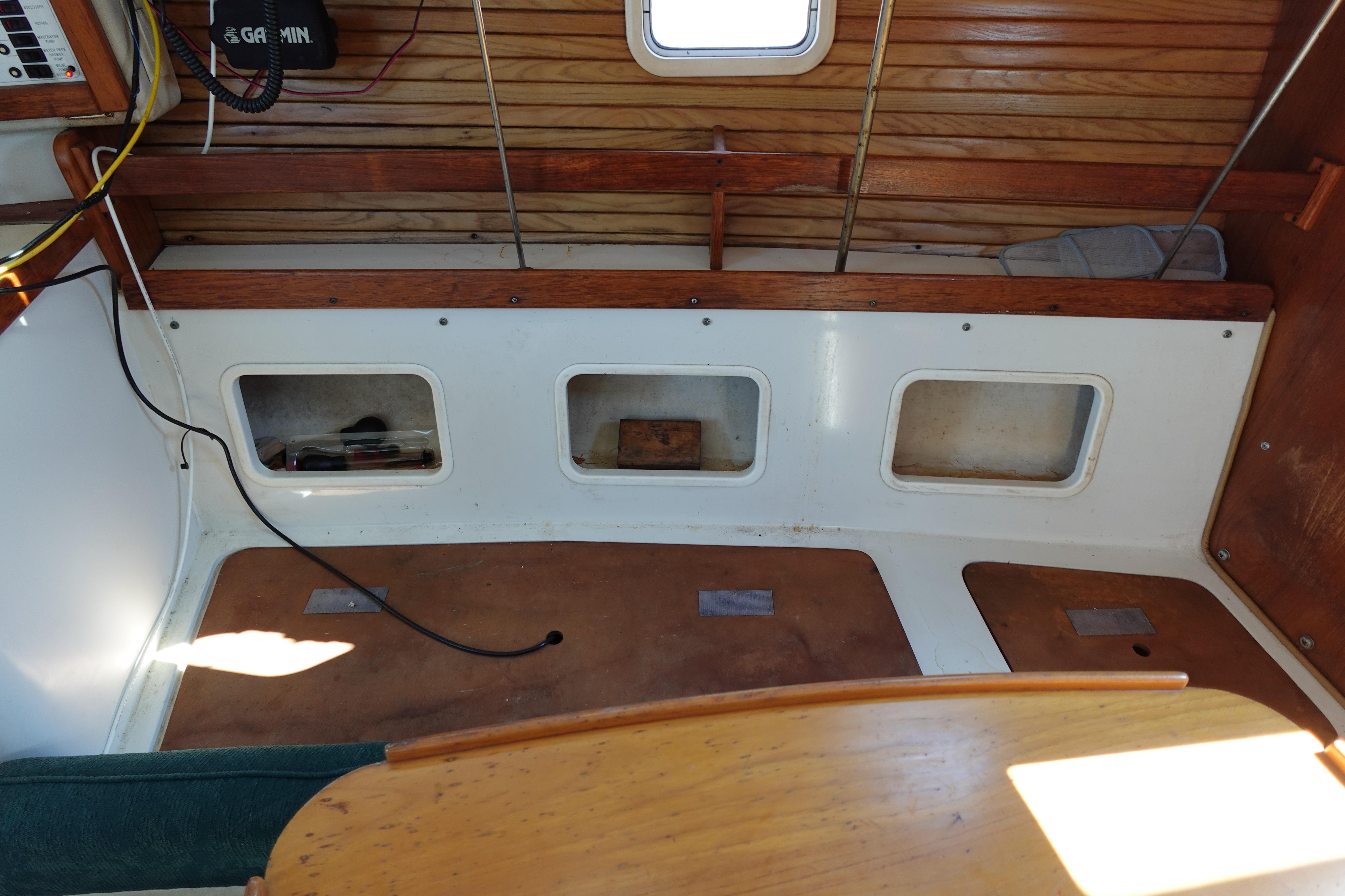 Interior of a 1997 Catalina 28 sailboat, featuring wooden accents and storage compartments.