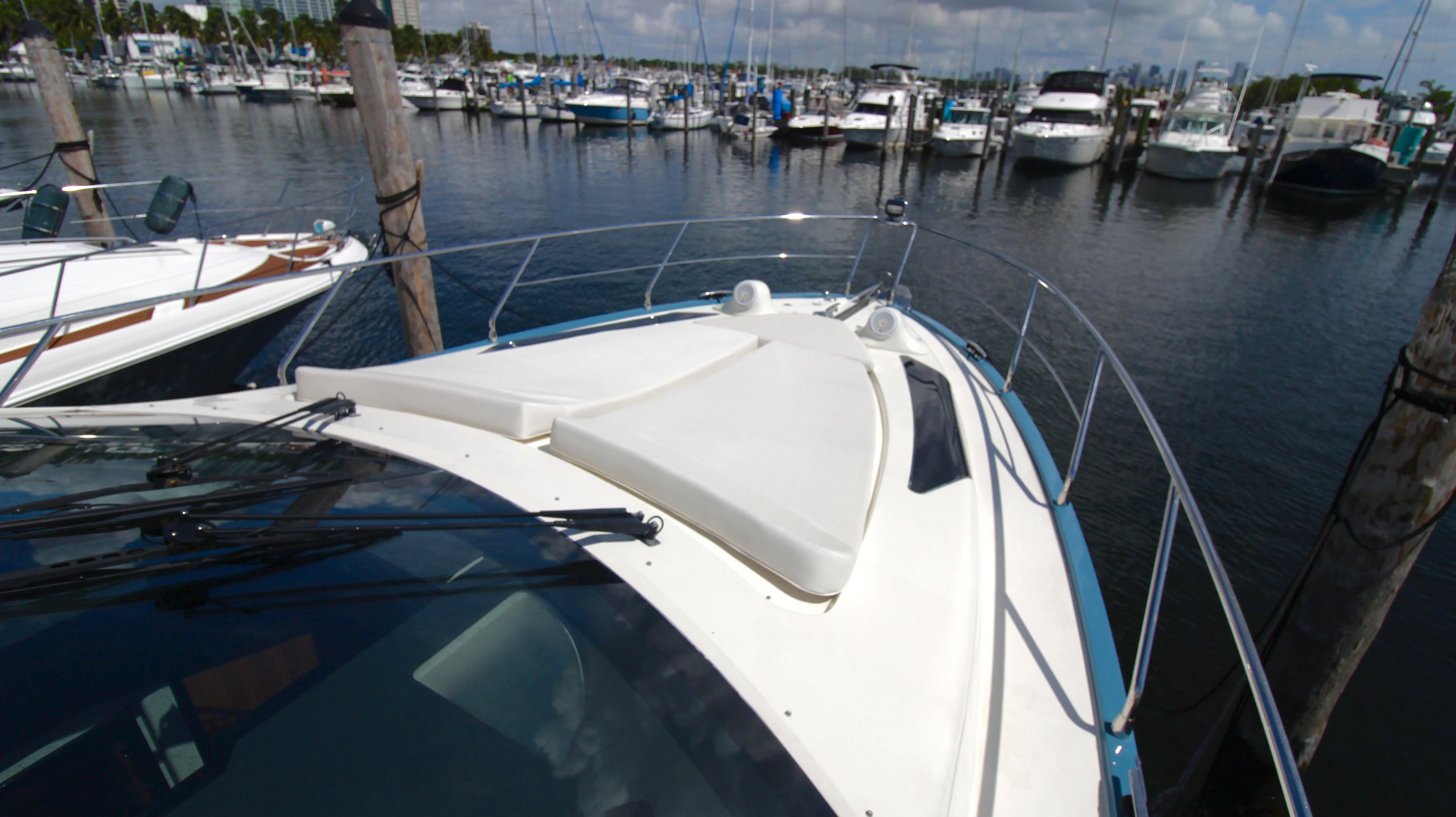 A 2010 Marquis Sport Coupe docked in a marina, surrounded by other boats.
