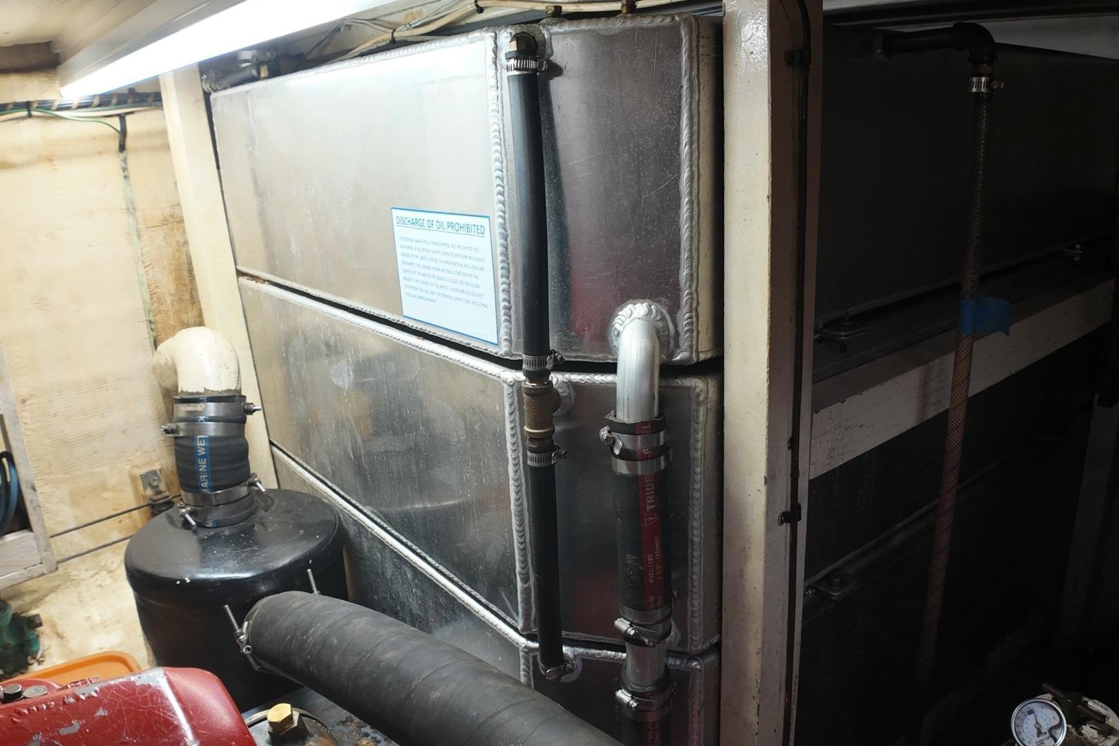 Engine room of a 1978 Grand Banks 42 Classic yacht, featuring metal tanks and piping.
