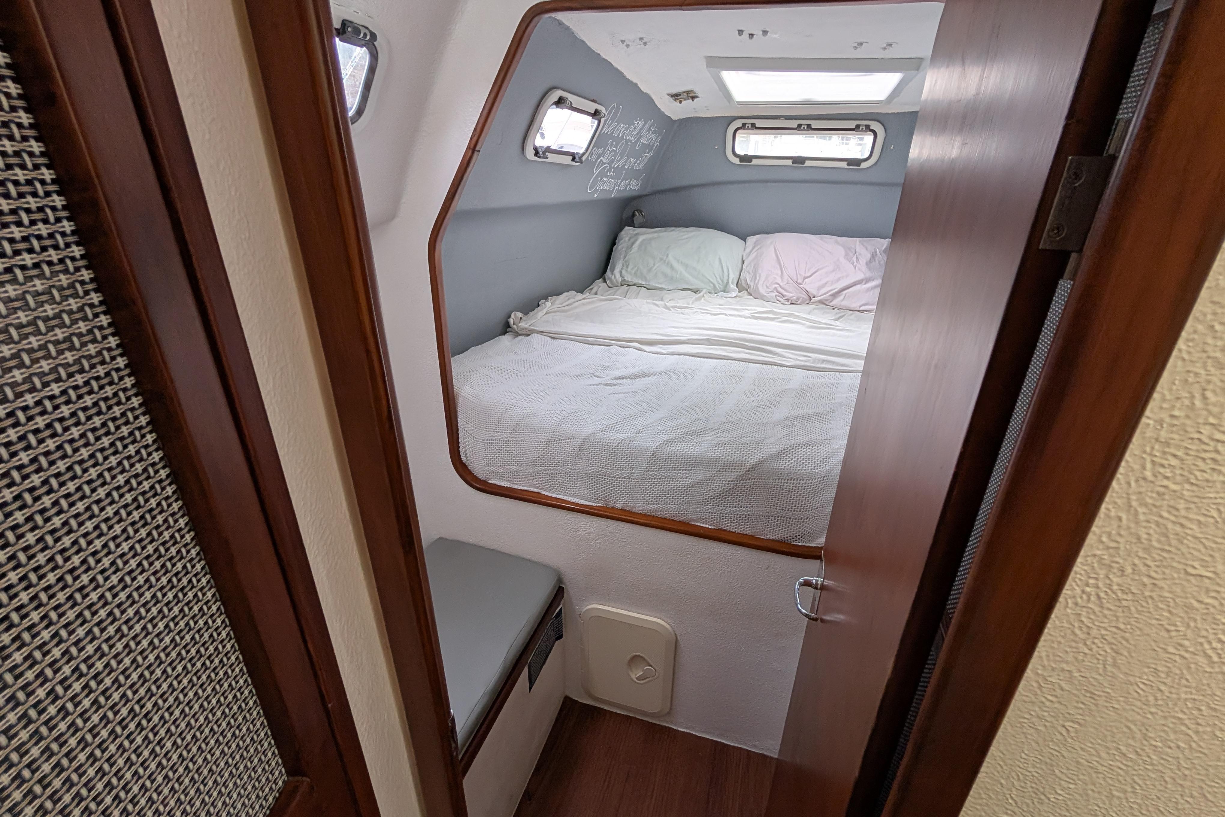 Cozy cabin interior of a 1999 Island Spirit 37 sailboat with a comfortable bed.