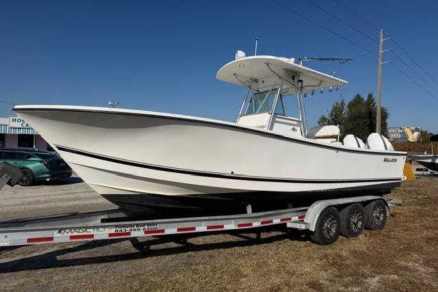 2002 Regulator 26 Forward Seating boat on trailer, side view, outdoors.