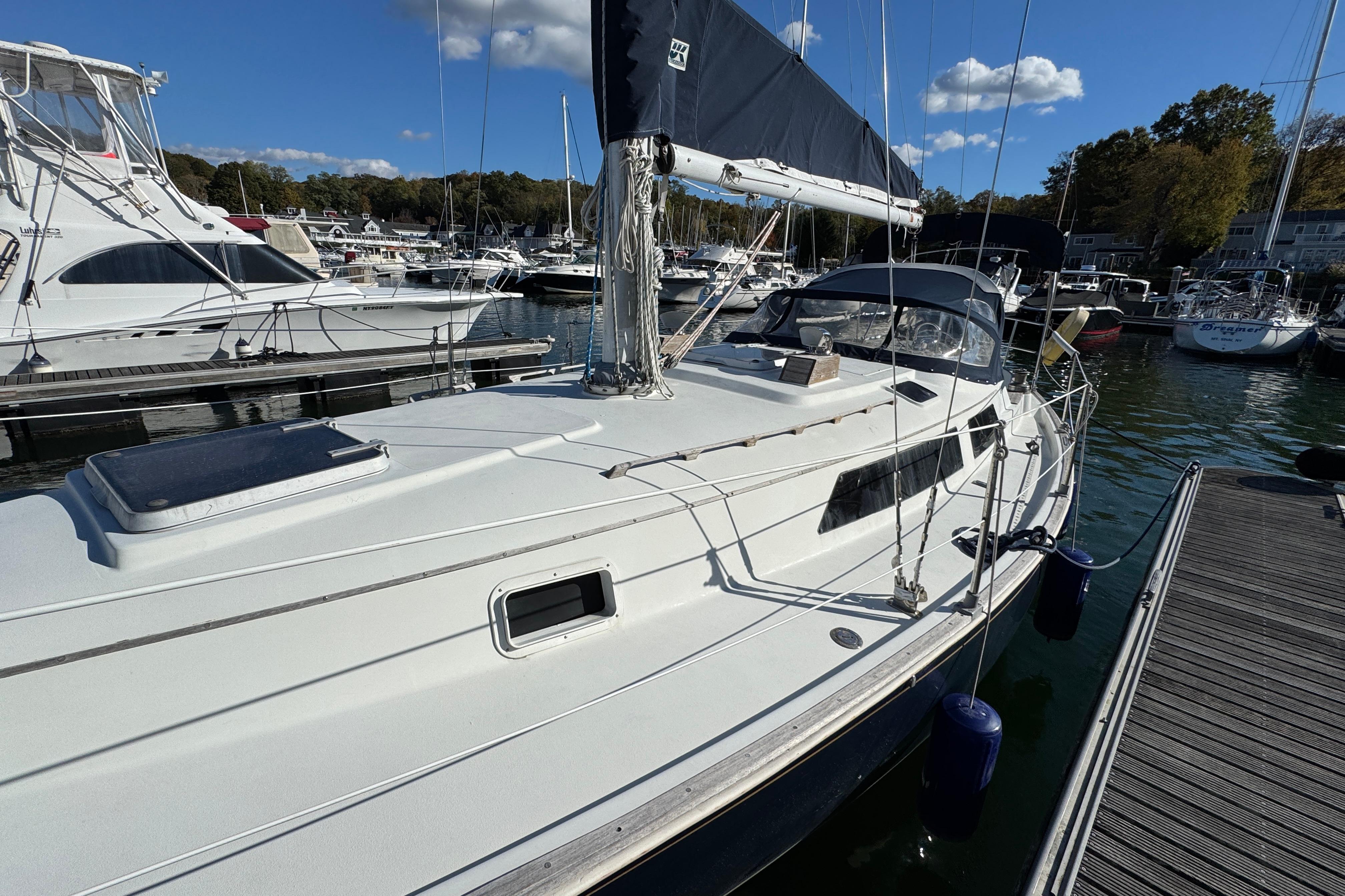1984 C&C Landfall sailboat docked at marina under clear blue sky.
