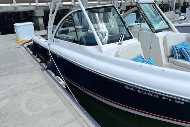 2013 Pursuit DC 265 Dual Console boat docked with blue and white seating.