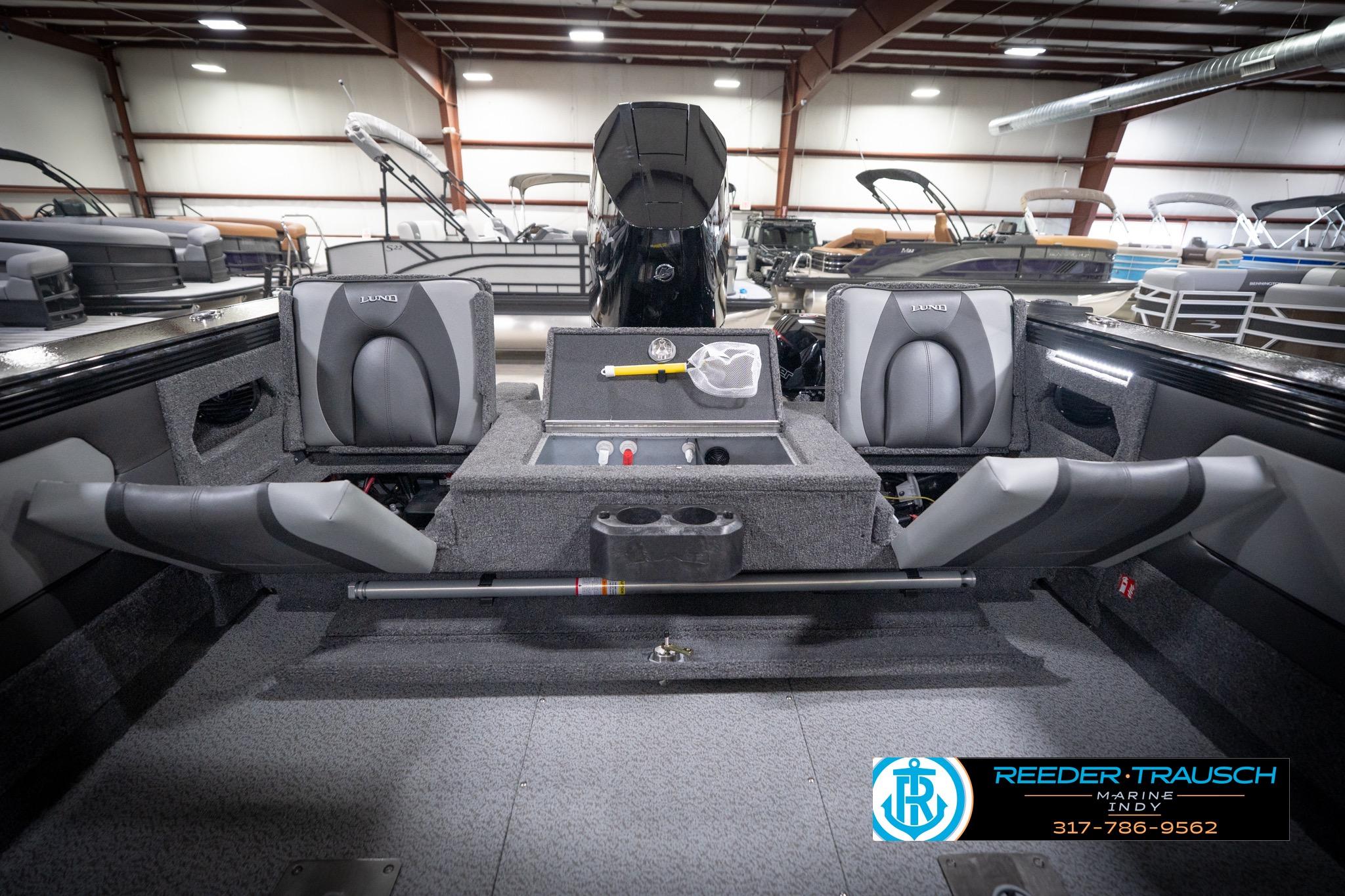 2026 Lund 2275 Baron boat interior with seating and storage, displayed in a showroom.