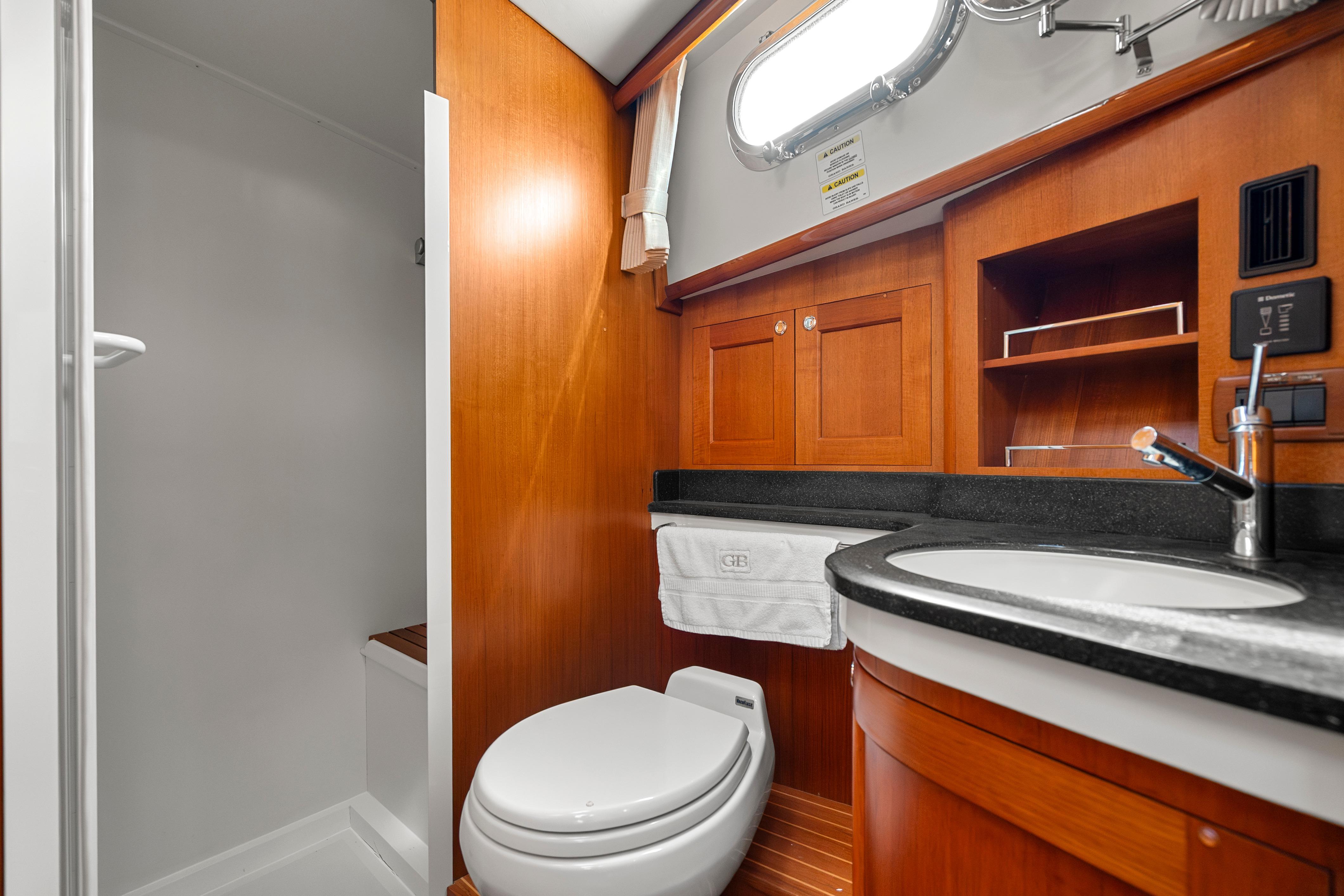 Luxurious 2011 Grand Banks 46 Eastbay SX yacht bathroom with wood cabinetry and modern fixtures.