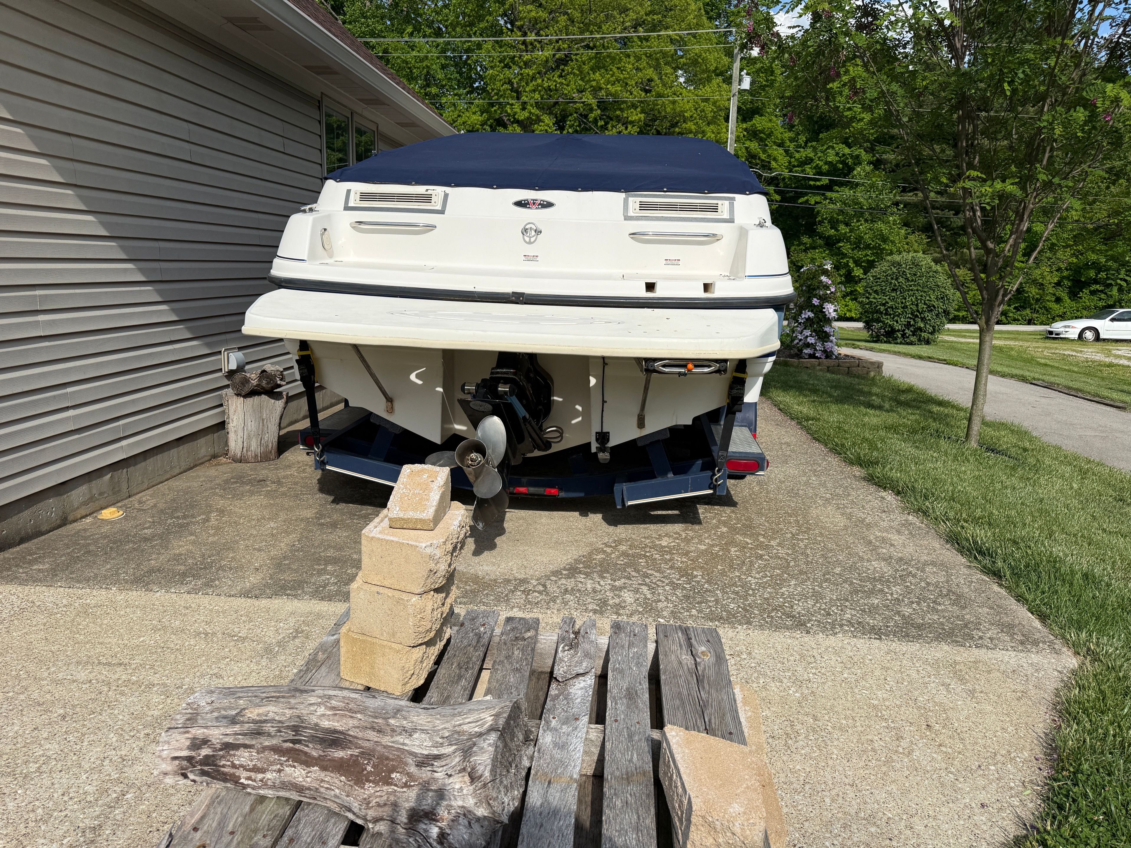 1999 Custom 2335 Cuddy Cabin boat on trailer in driveway.