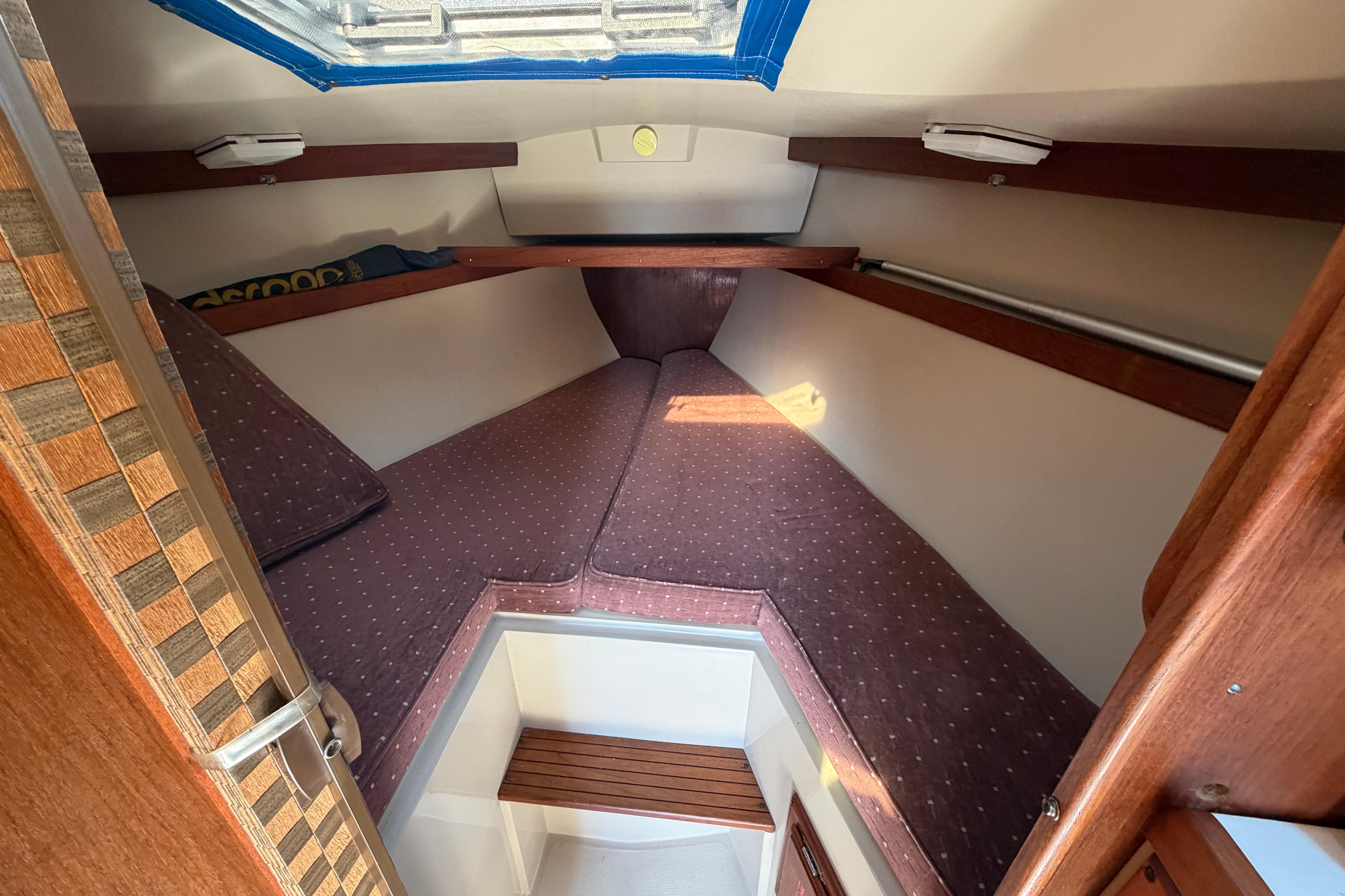 Cozy cabin interior of 1988 Catalina 30 MkII sailboat with cushioned V-berth.