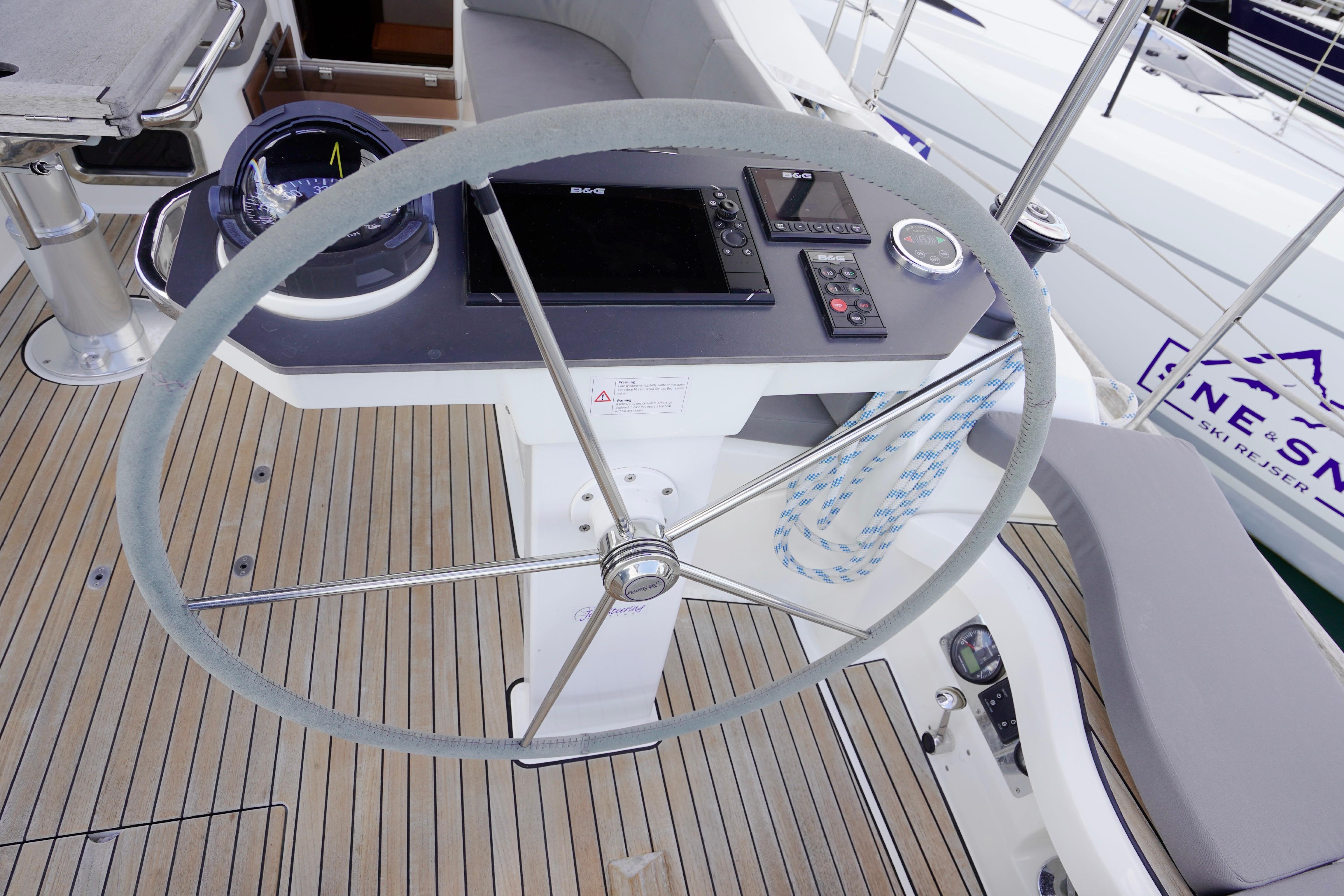 Steering wheel and navigation controls on a 2019 Bavaria Vision 42 yacht deck.