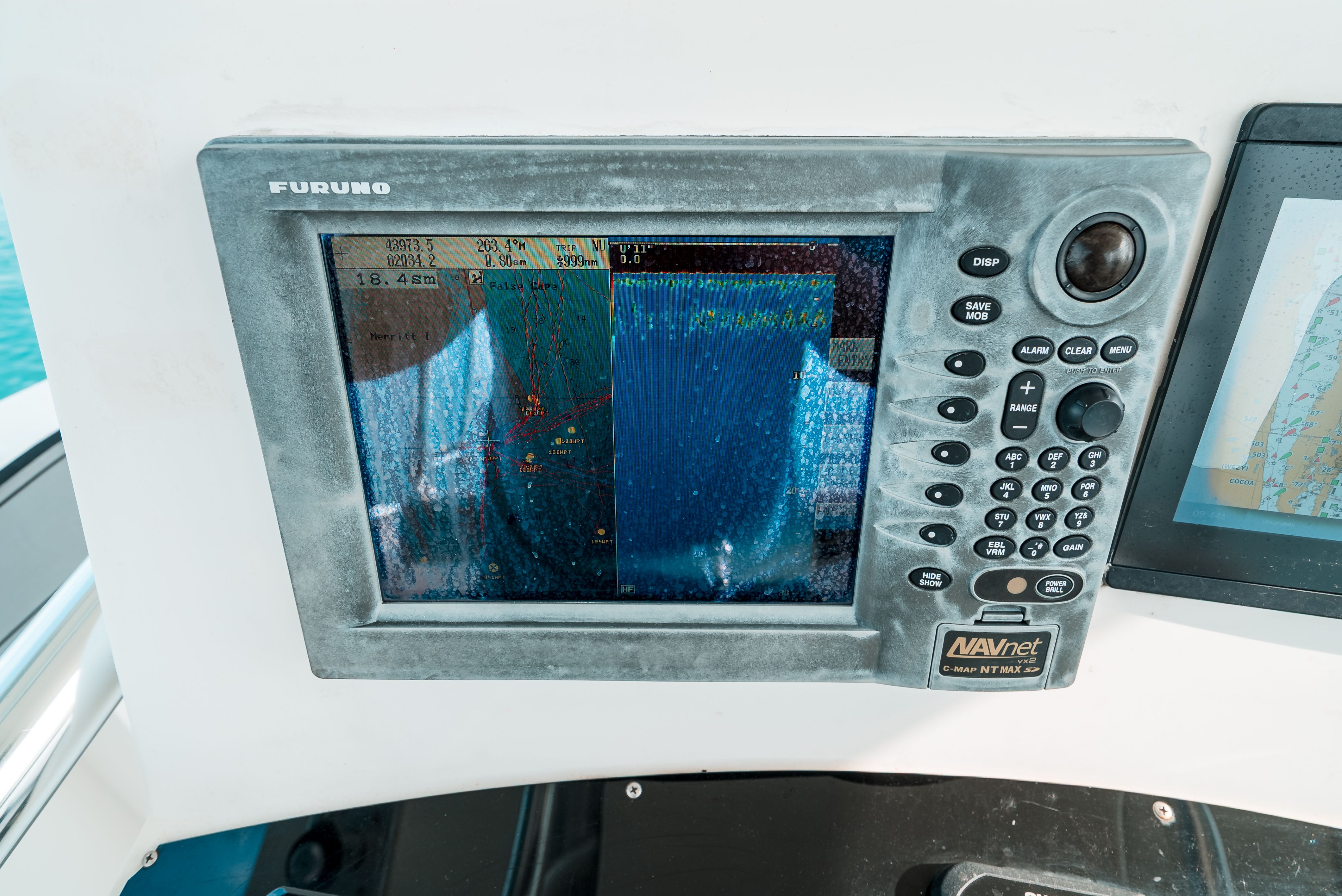 Navigation system on a boat with screen and buttons.