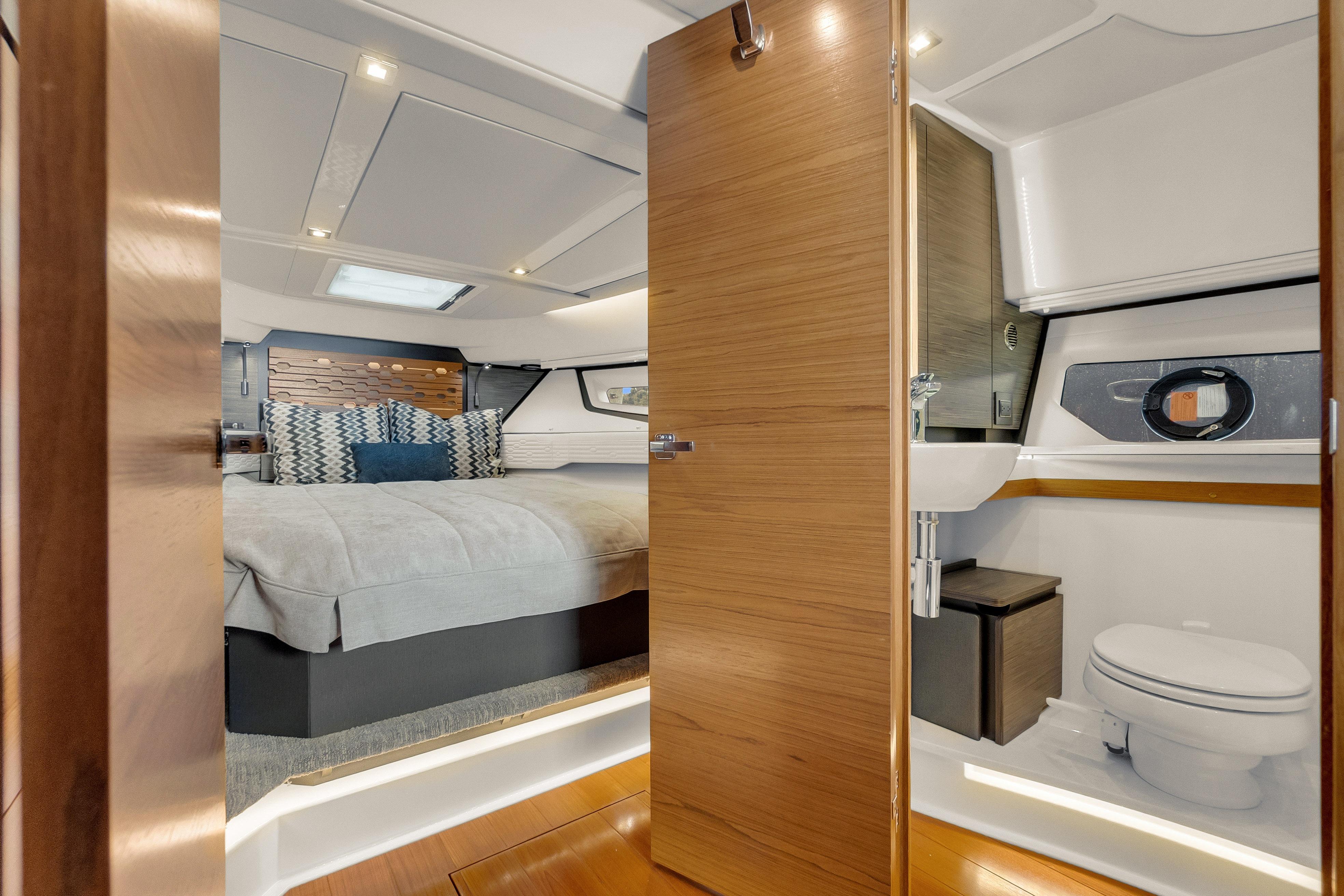 Luxurious interior of 2021 Tiara Sport 43 LE yacht featuring bedroom and bathroom.