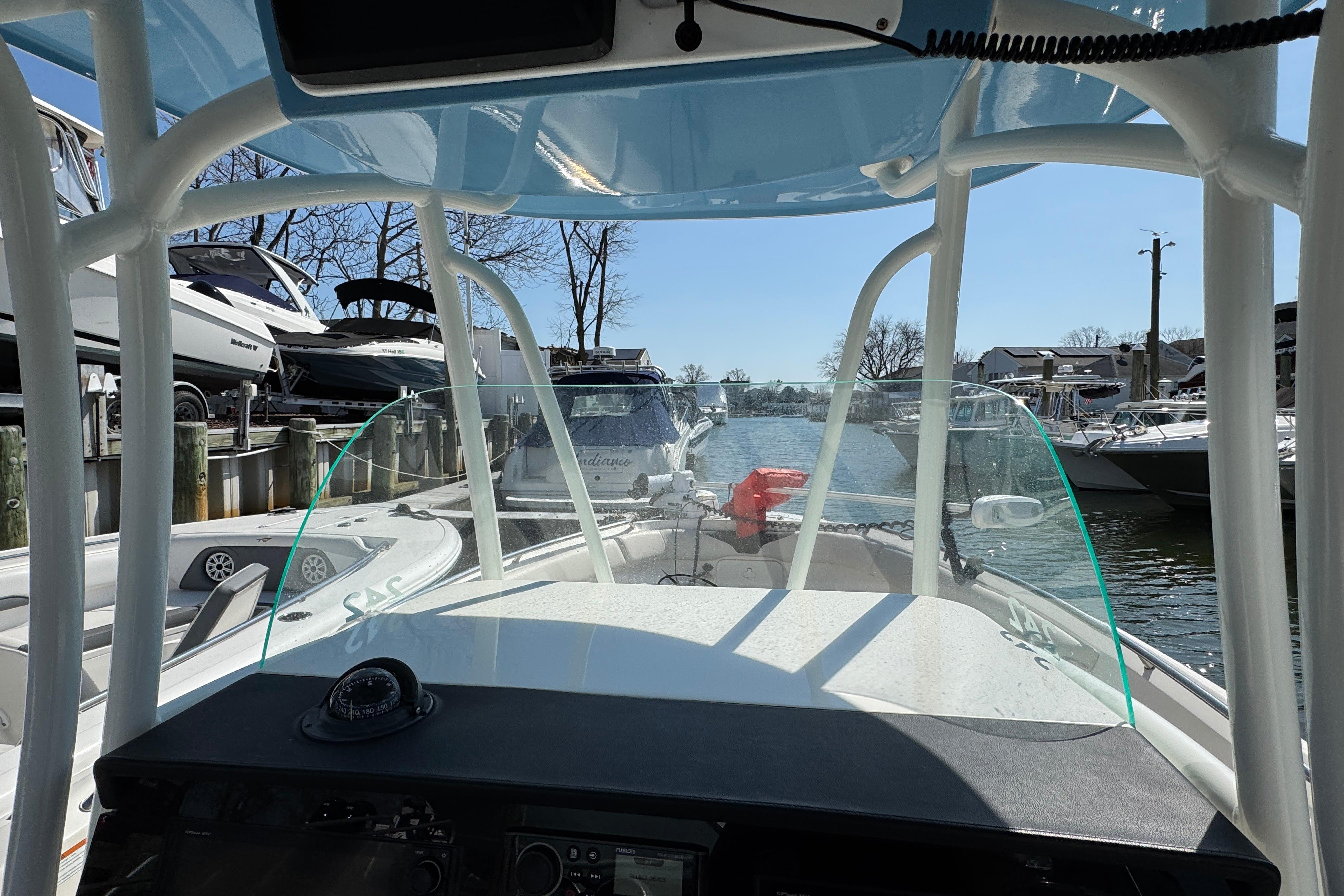 2022 Sailfish 242 CC boat interior view at marina, showcasing helm and windshield.