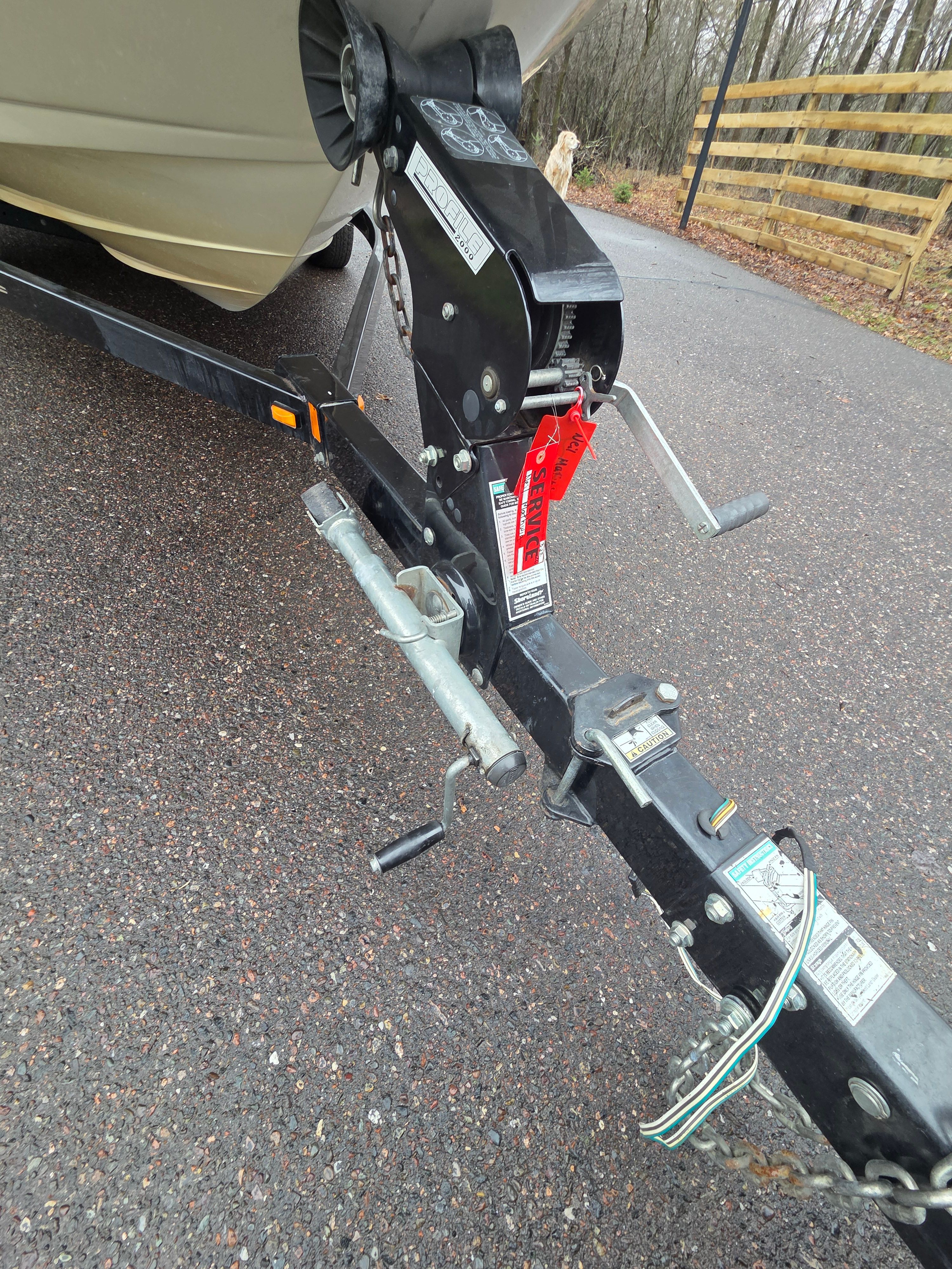 Trailer of a 2002 Sea Ray 182 boat on wet pavement.