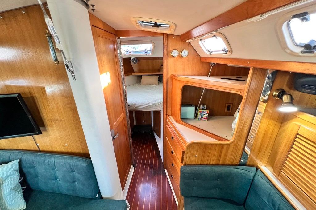 Interior of a 1999 Catalina 36 MkII sailboat, featuring wood paneling and cozy cabin space.