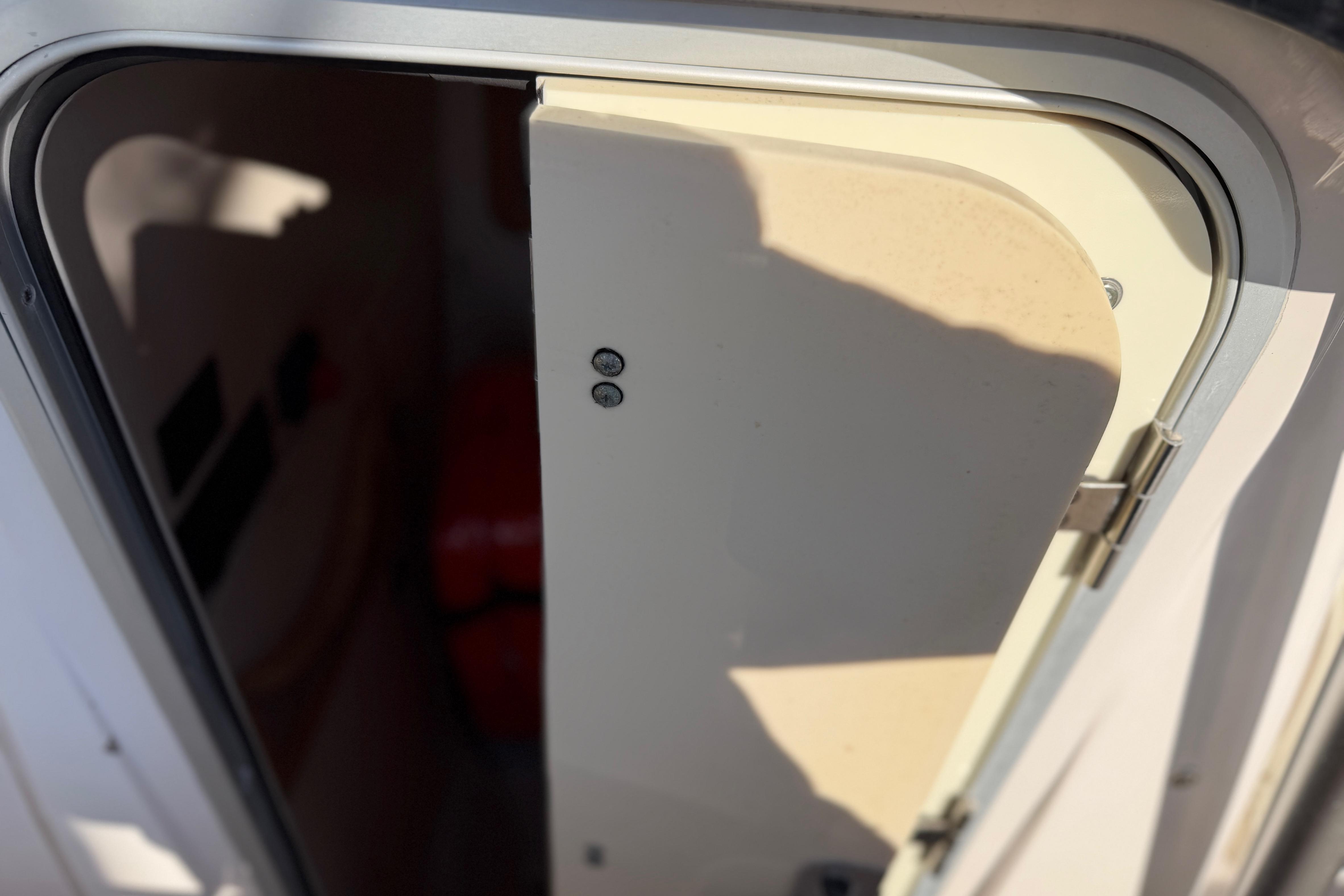 2004 Grady White 273 boat cabin door partially open, showing interior shadows.