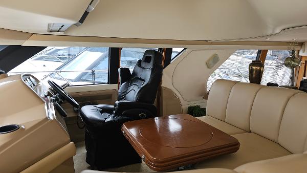 Interior of 2000 Carver 450 Voyager Pilothouse with leather seating and wooden table.