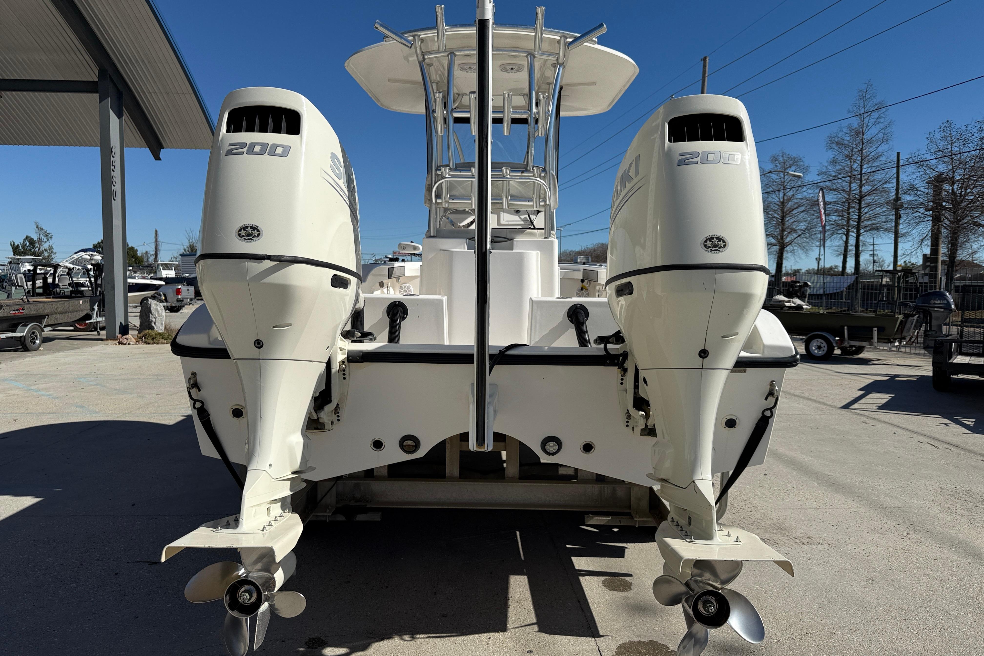2020 Tideline 235 Hybrid boat with dual 200 HP outboard engines, docked outdoors.
