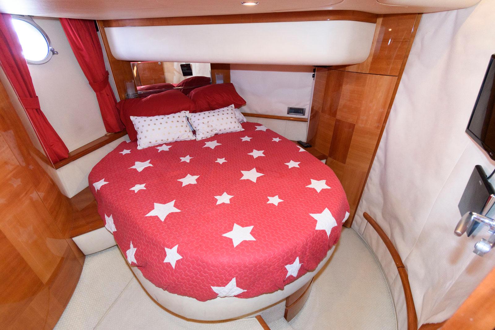 Luxurious bedroom in 2005 Azimut 50 Flybridge yacht with star-patterned bedding.