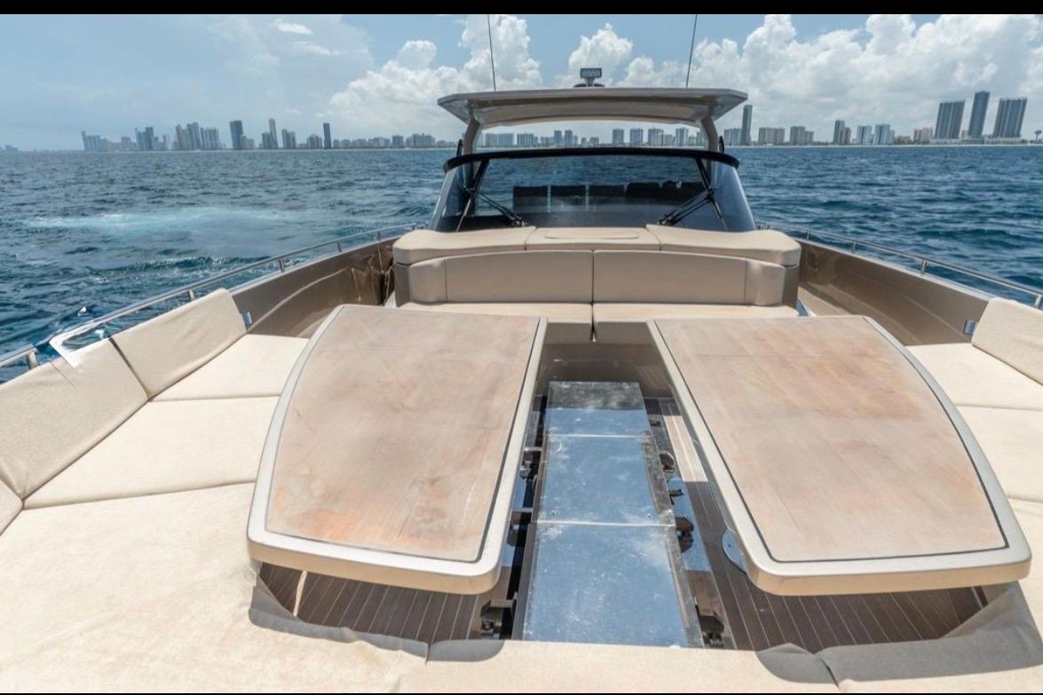 Luxurious 2019 CNM 54 yacht with spacious deck, city skyline in background.
