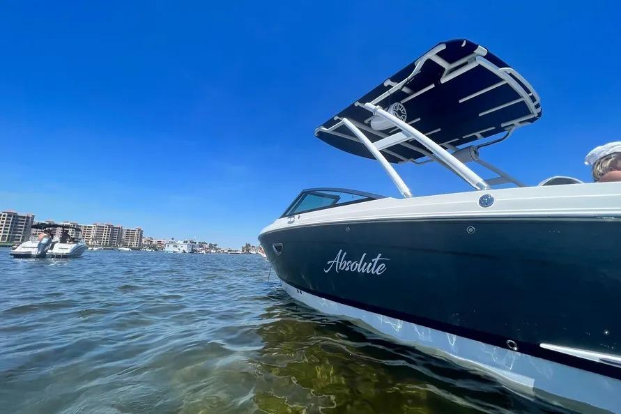 2022 Cobalt R6 Outboard boat named "Absolute" on clear water under blue sky.